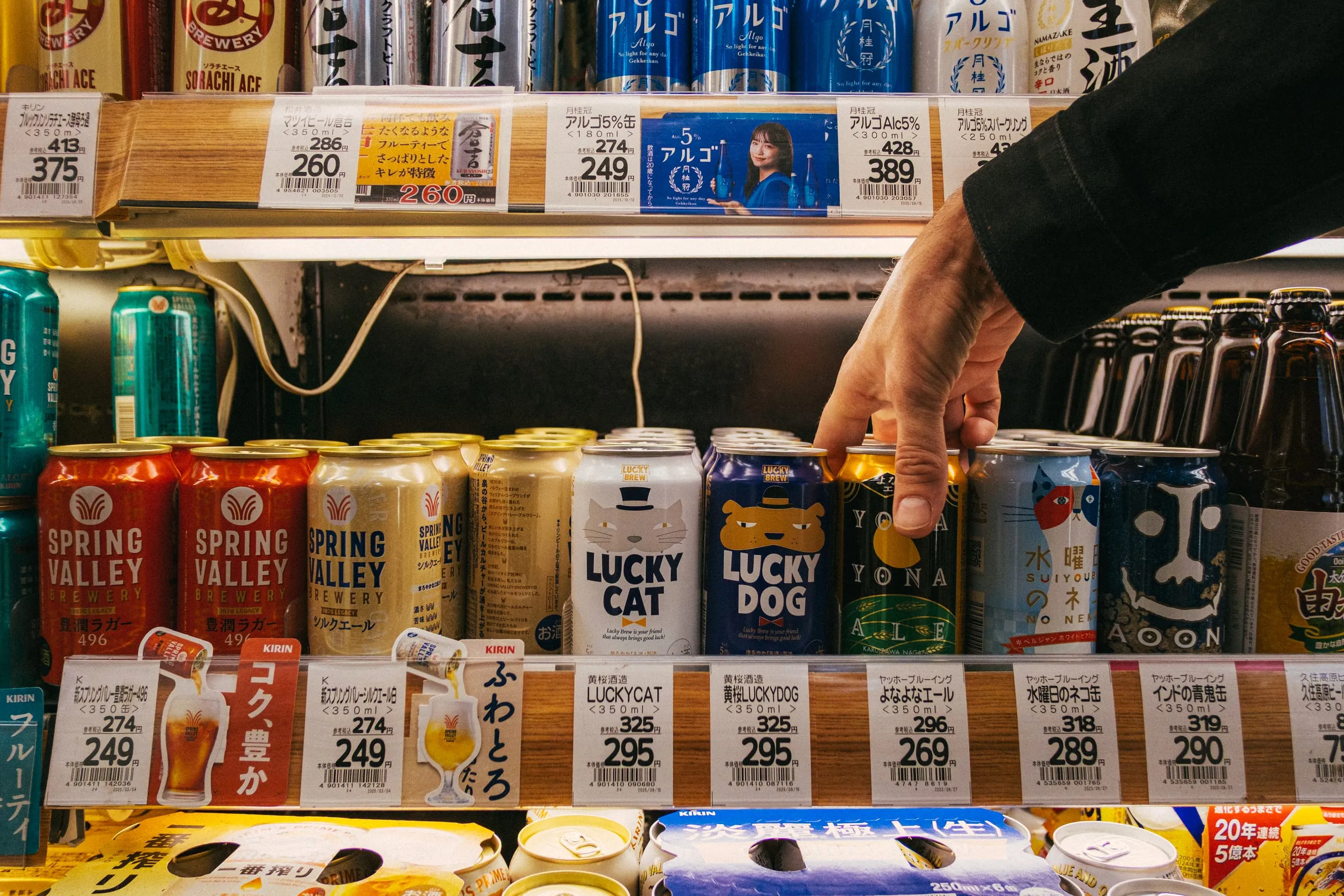 Oscar reaches for a can of Yona ale from a supermarket fridge