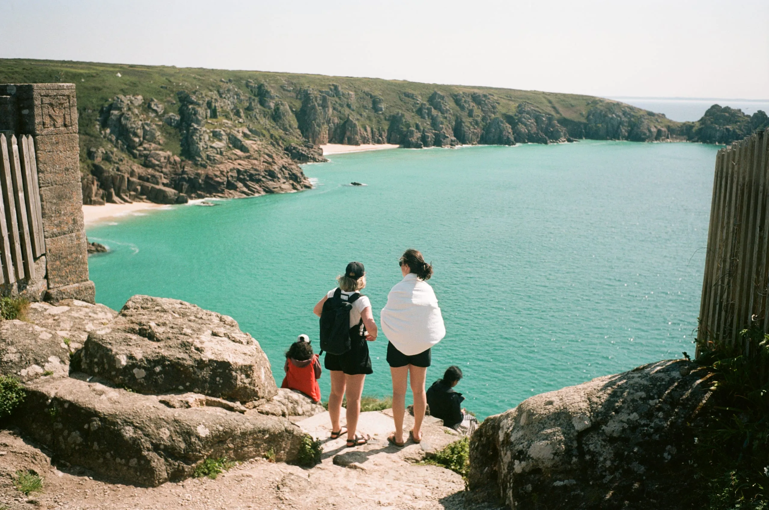 Two friends look over a bay in Porthcurno