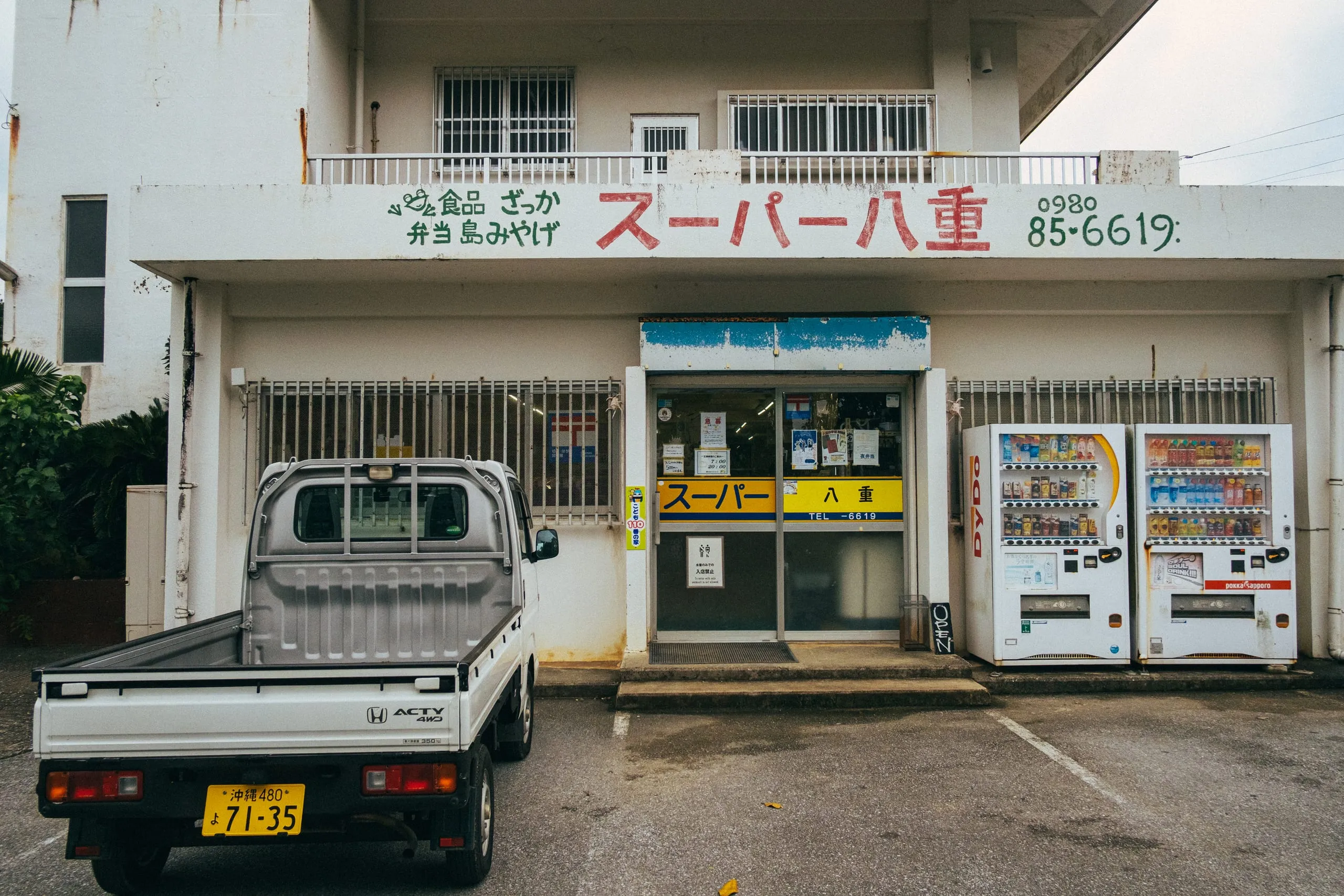 A kei truck parked outside a small island grocery store