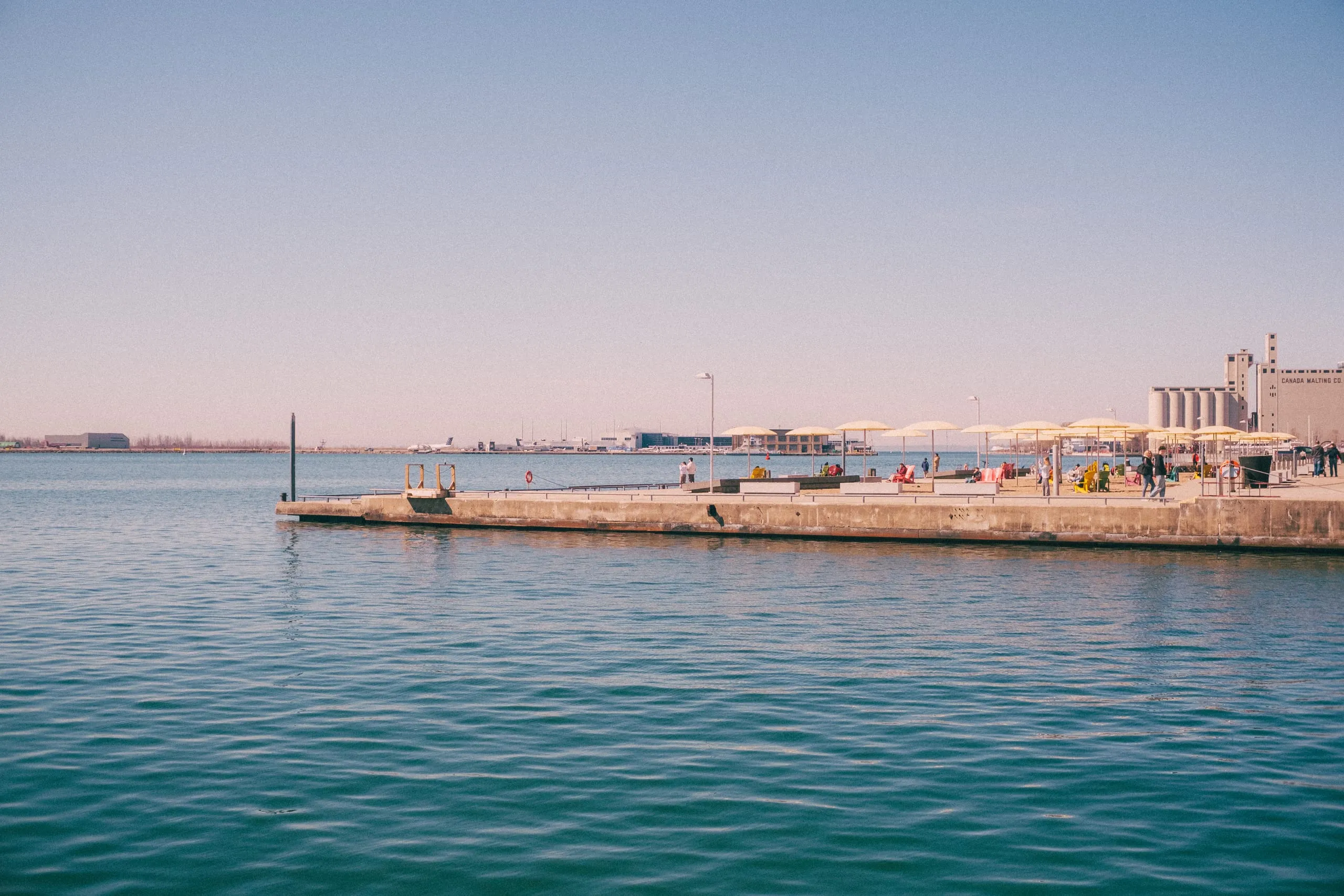 View over Queen's Quay and lake Ontario as planes take off from Billy Bishop Airport