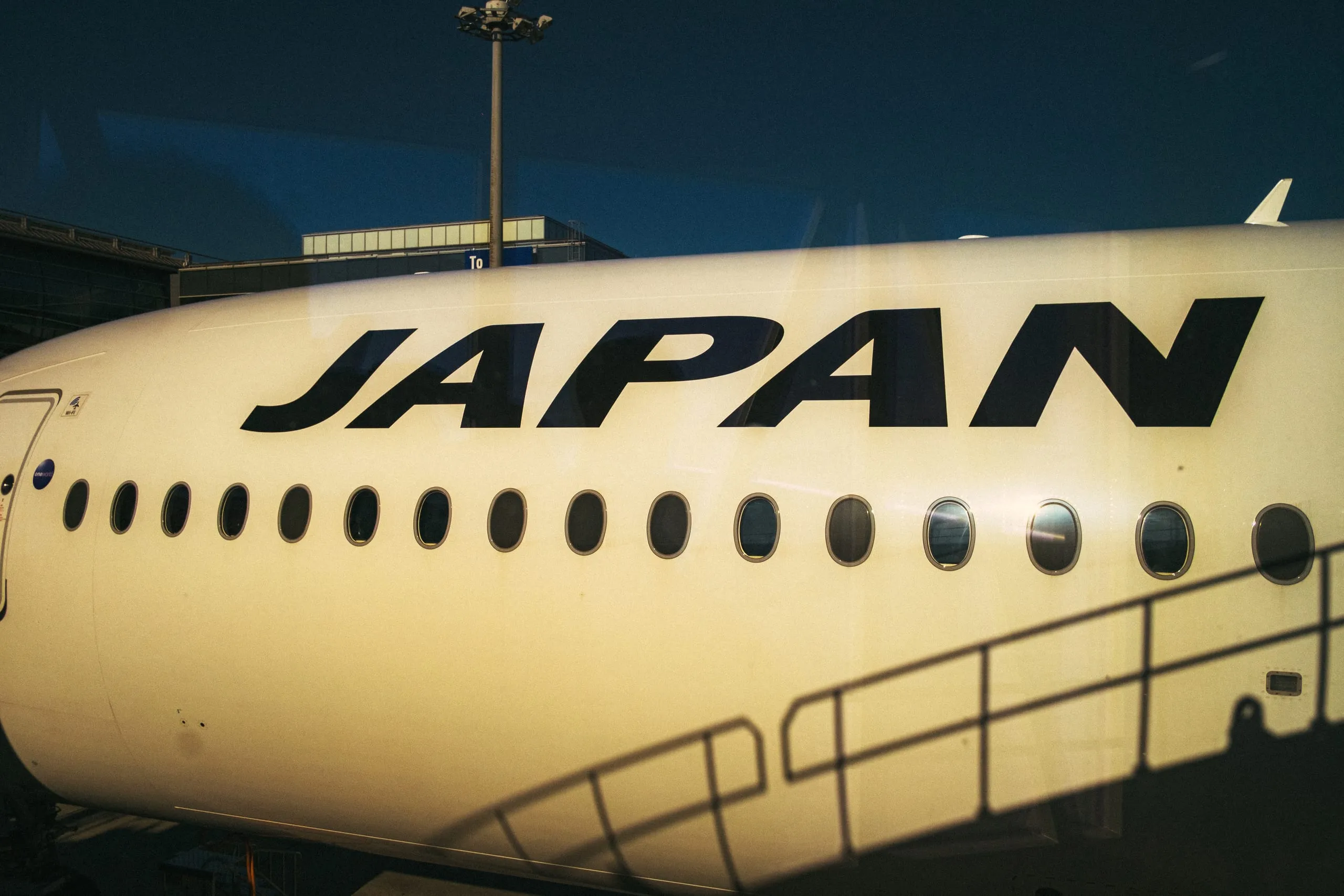 The fuselage of an aircraft lettered JAPAN at the gate, Haneda airport
