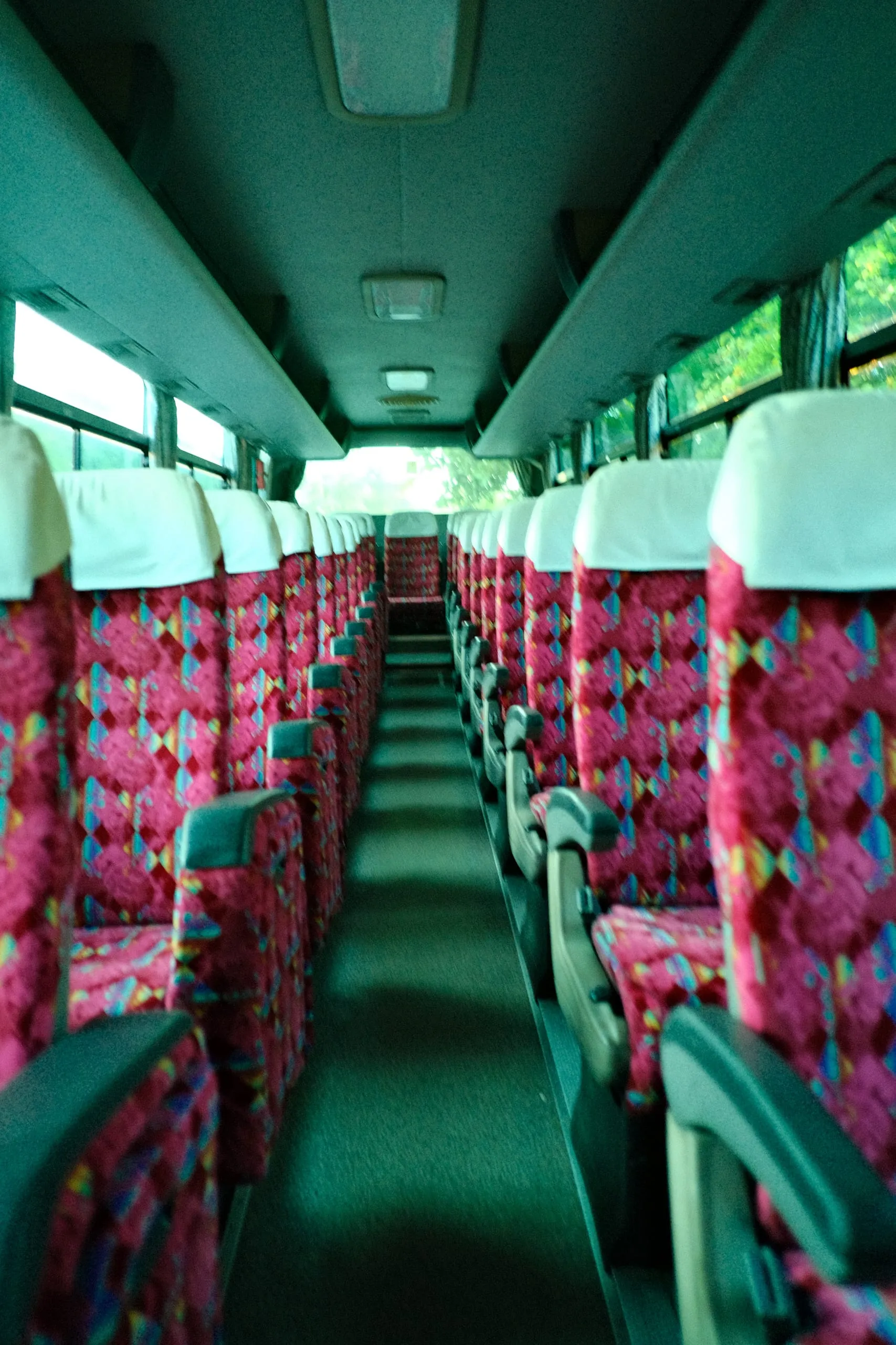 Empty patterned seats line the interior of a coach