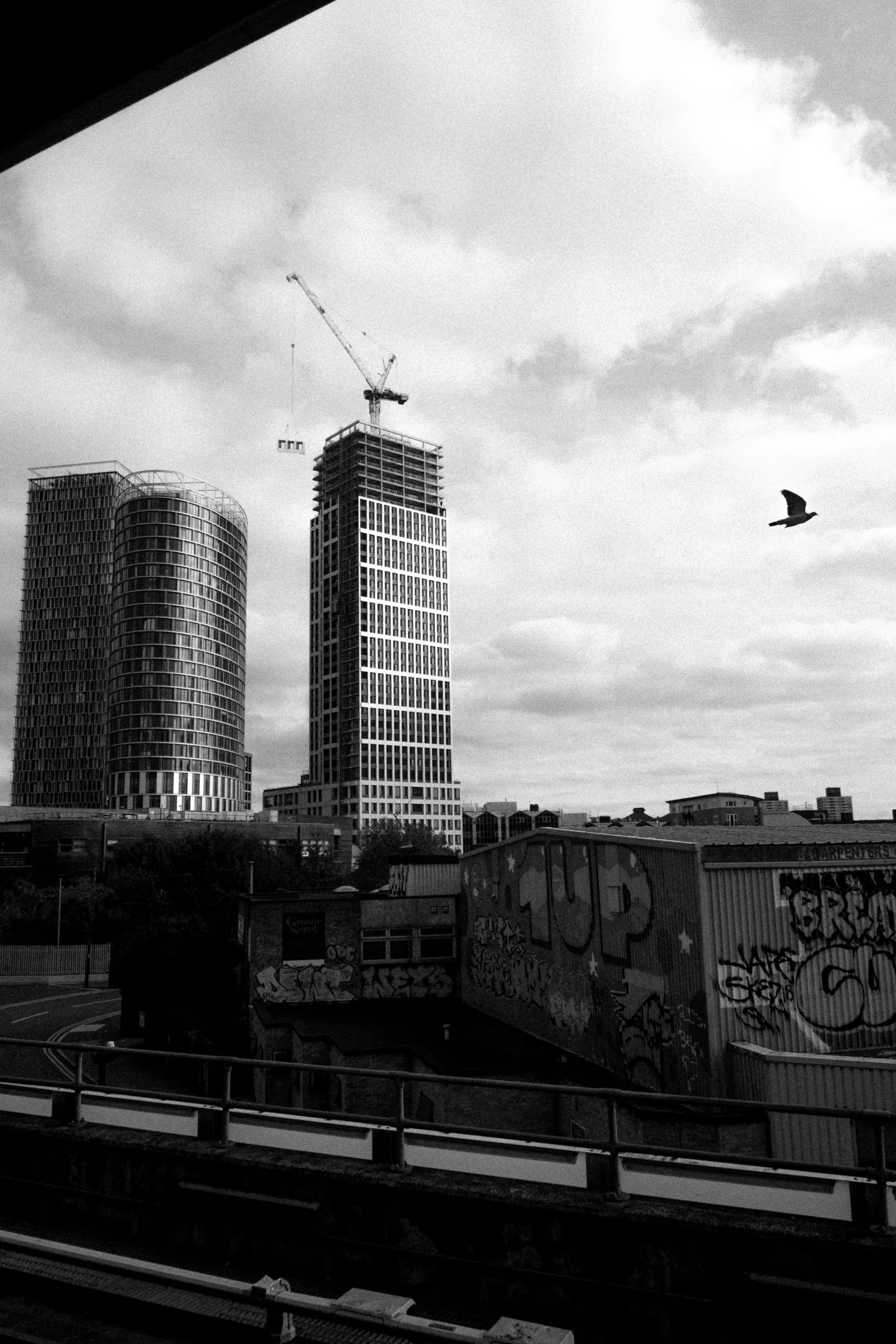 Tower blocks under construction and graffiti beside the railway, Stratford Station