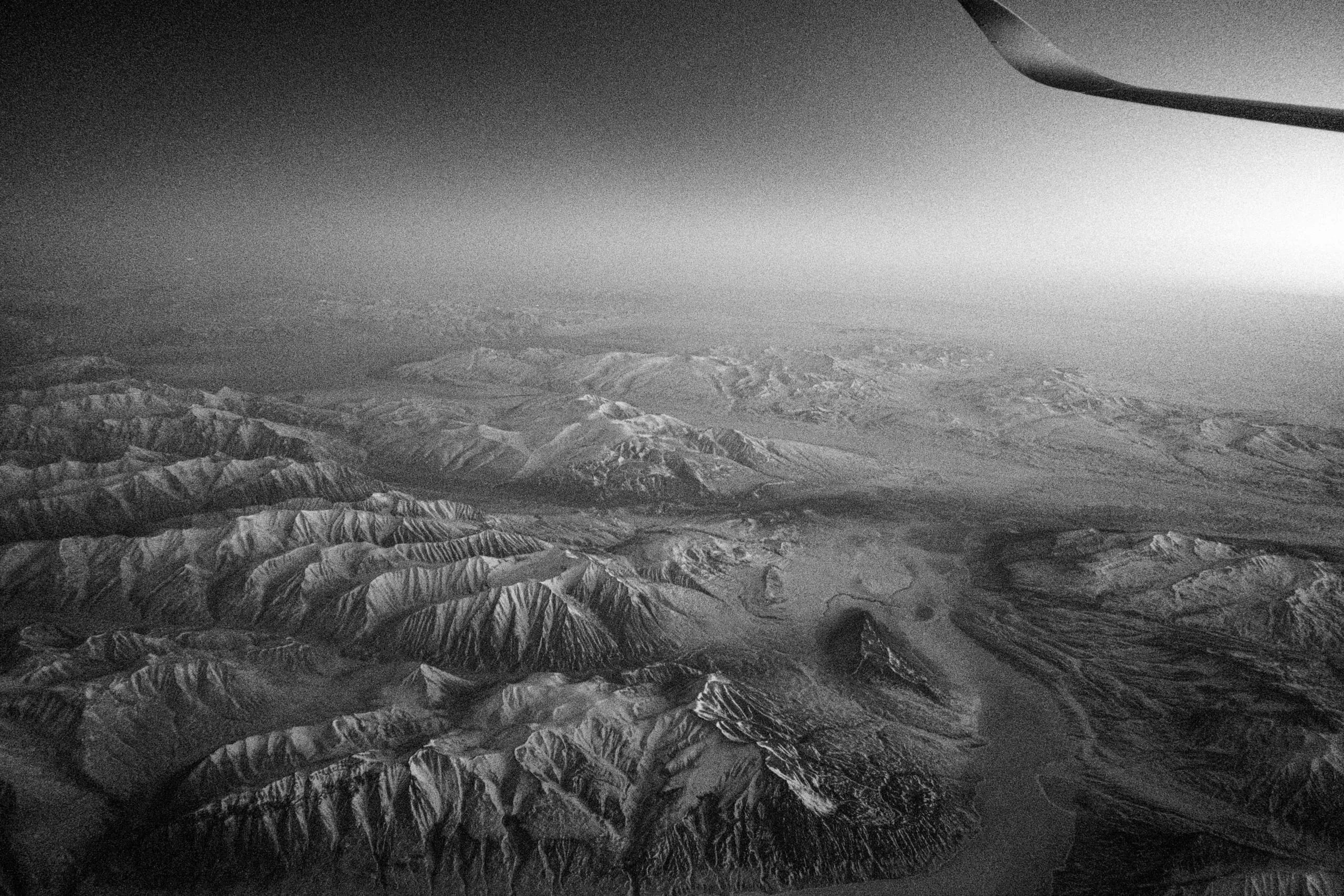 Snow-covered mountain ridges seen from an aeroplane window