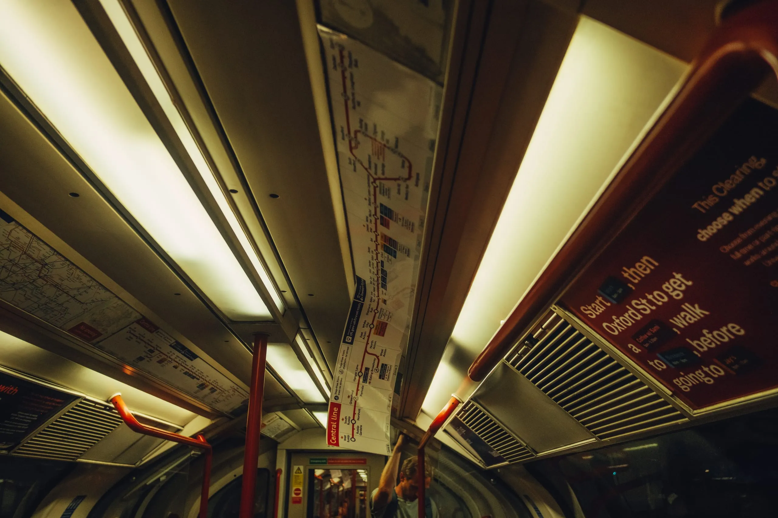 The interior of a London Underground carriage with a half-detached line map overhead