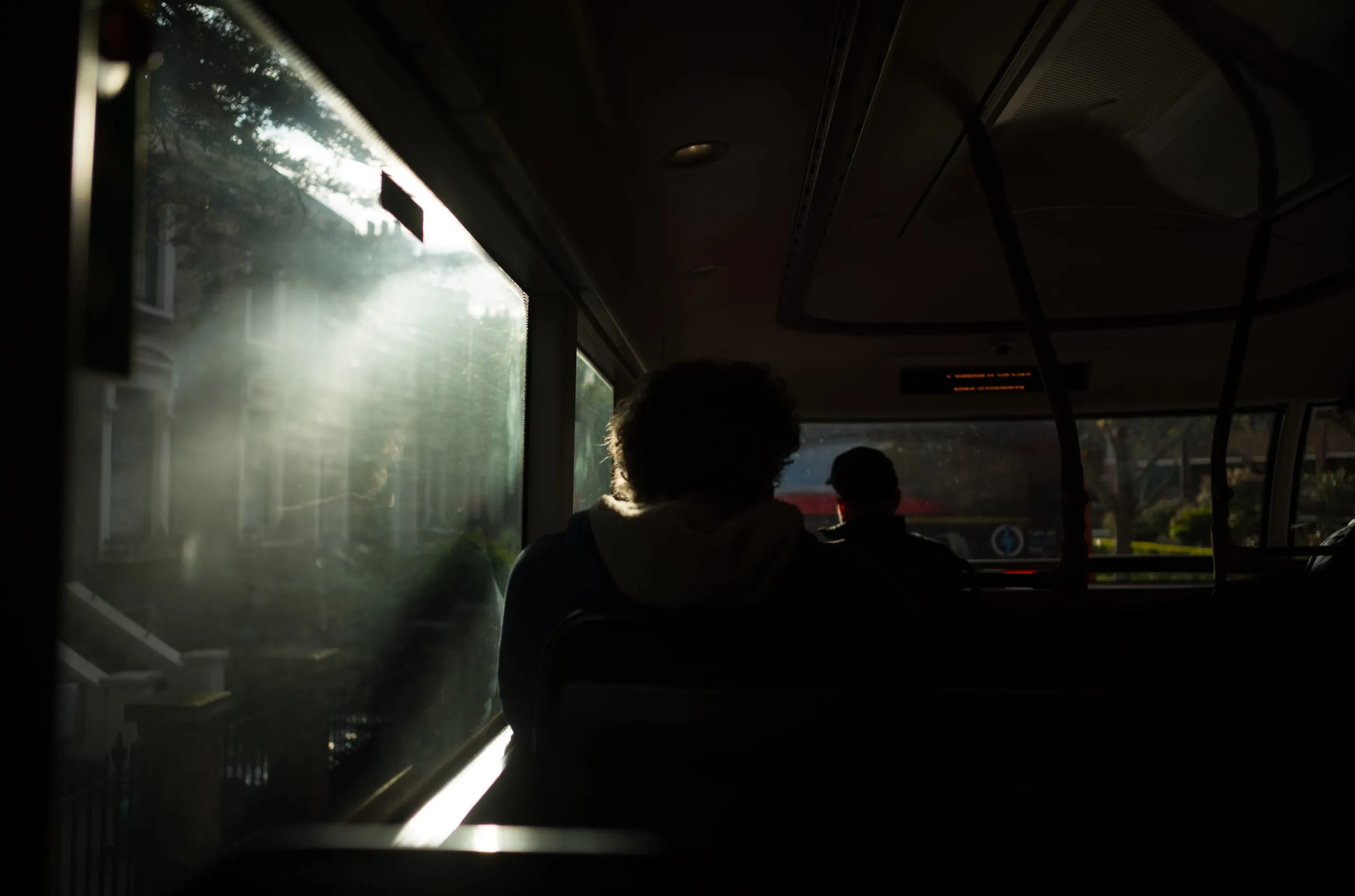 Passengers seen through the lit windows of a double-decker