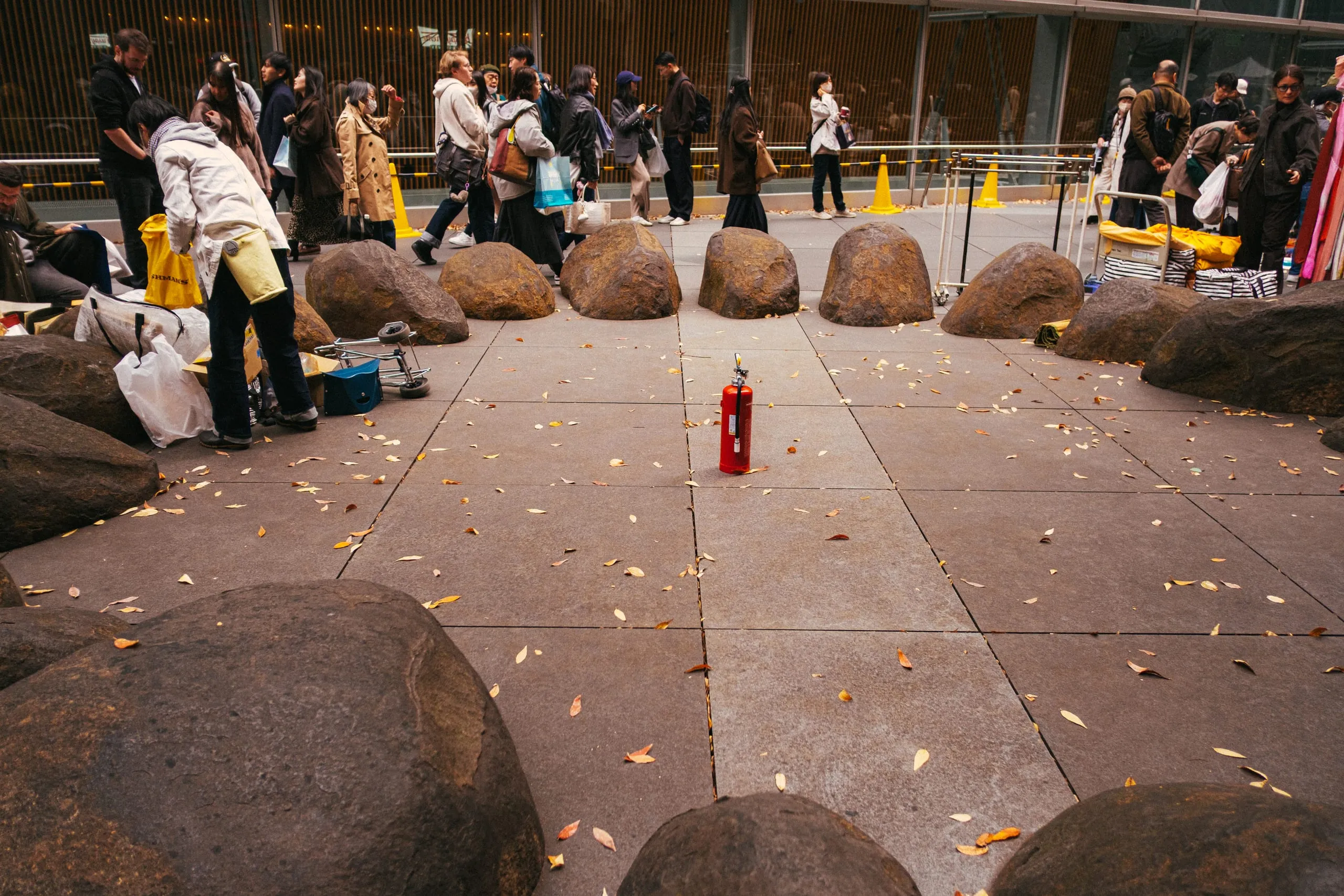 A fire extinguisher cleverly placed in a circle of boulders by a flea market