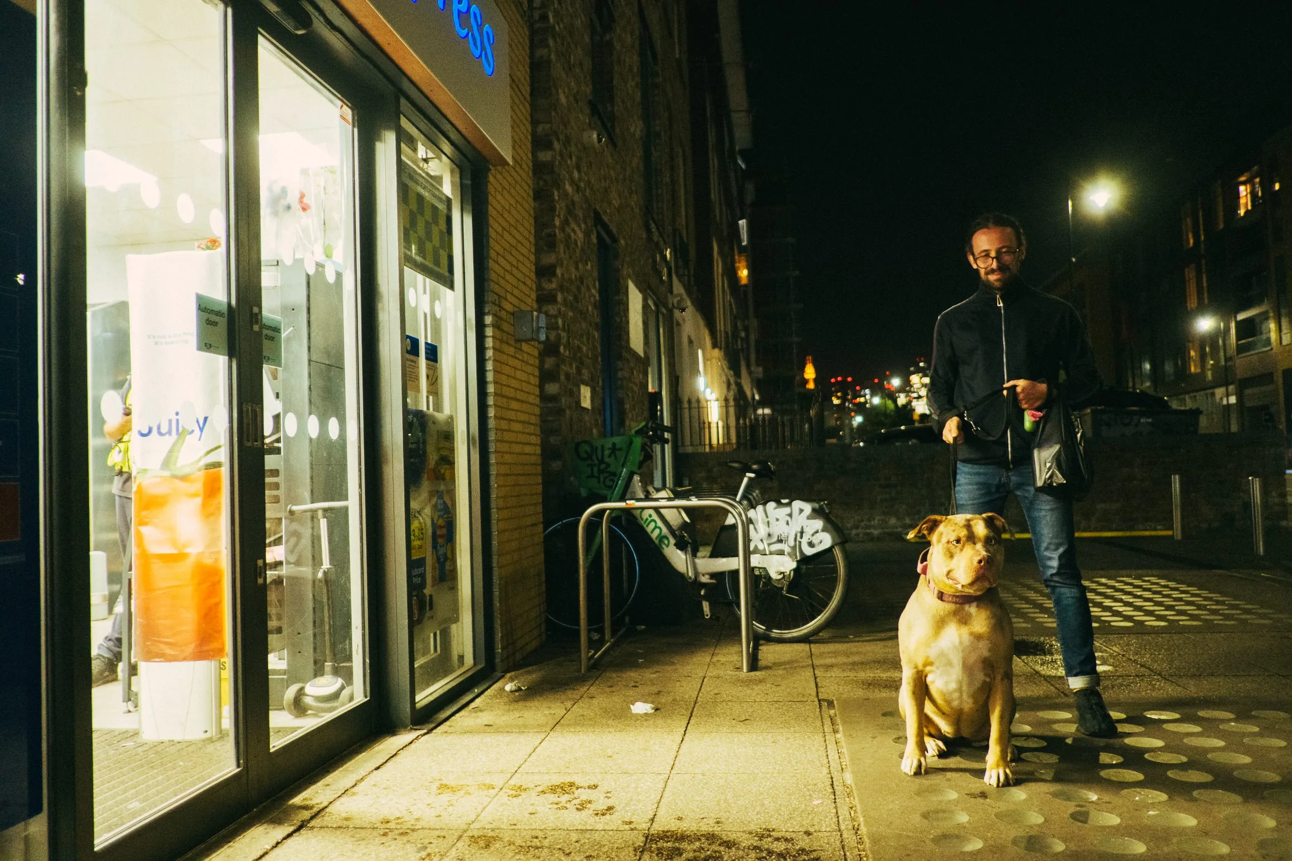 A man shows his a dog in front of the worst Tesco in the UK
