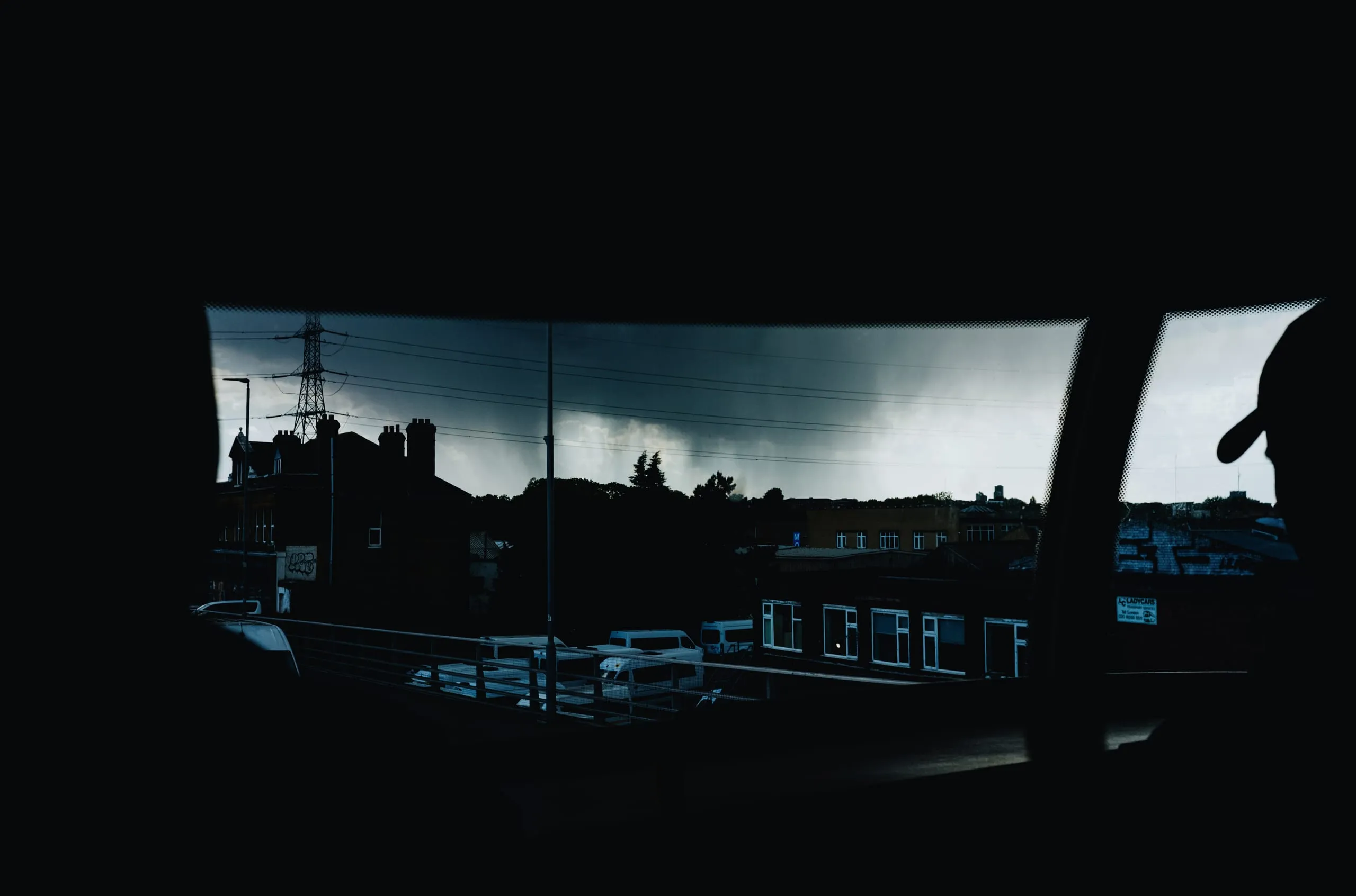 A distant rain cell pours over Clapton as seen from the 55 bus, Lea Bridge road, London