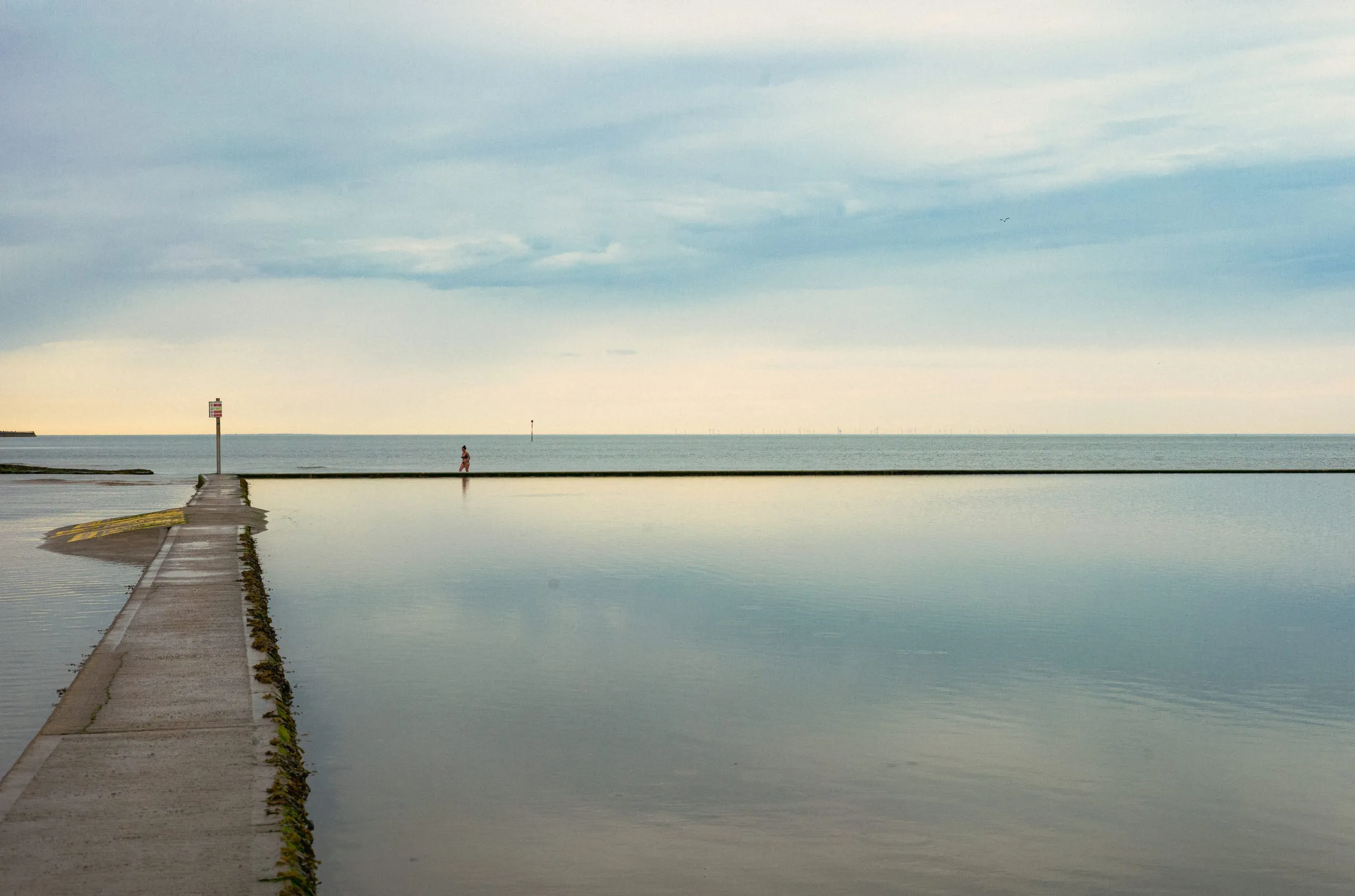 A woman walks by the margate beach boating pool