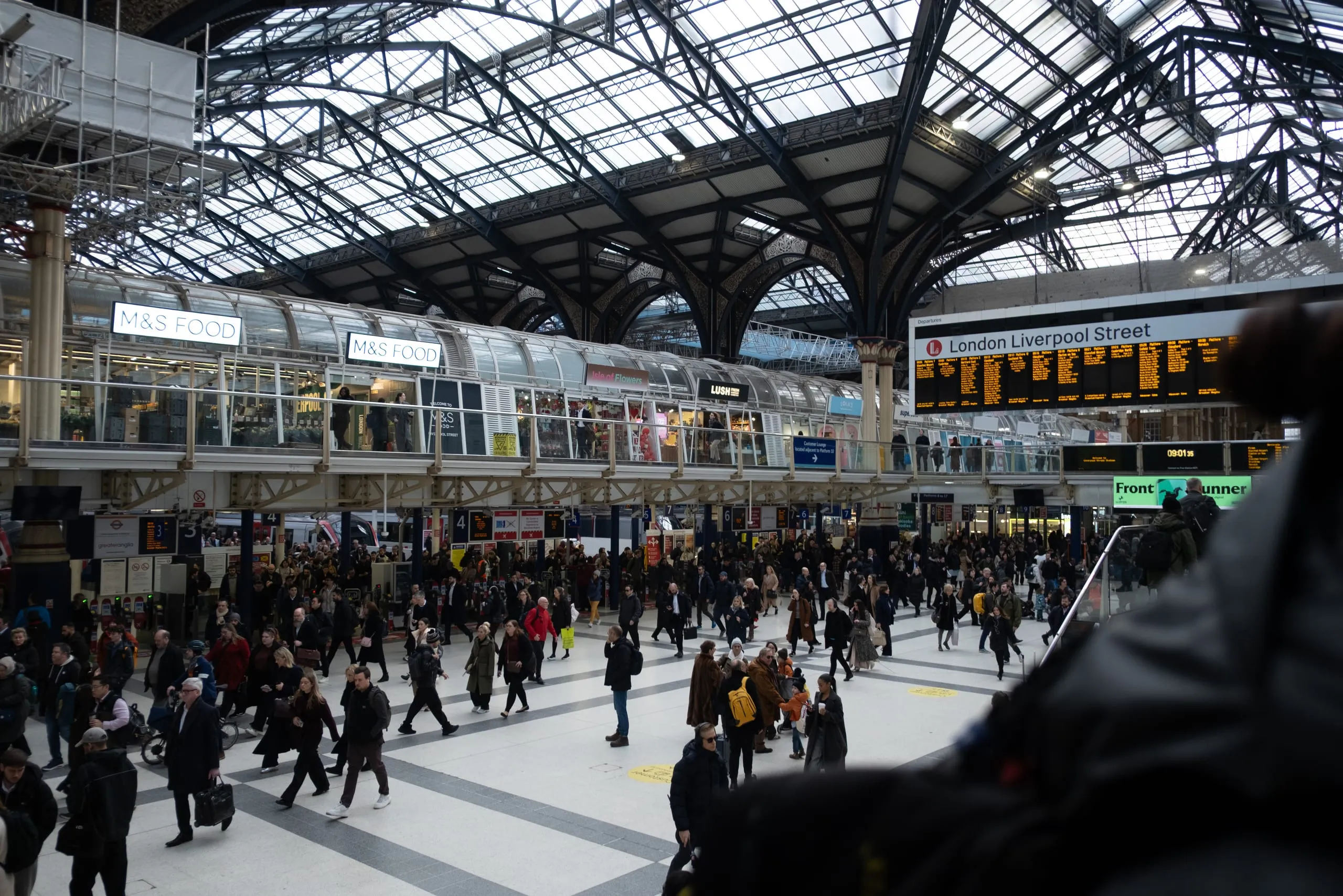 Commuters cross the concourse beneath the glass roof, London Liverpool Street station
