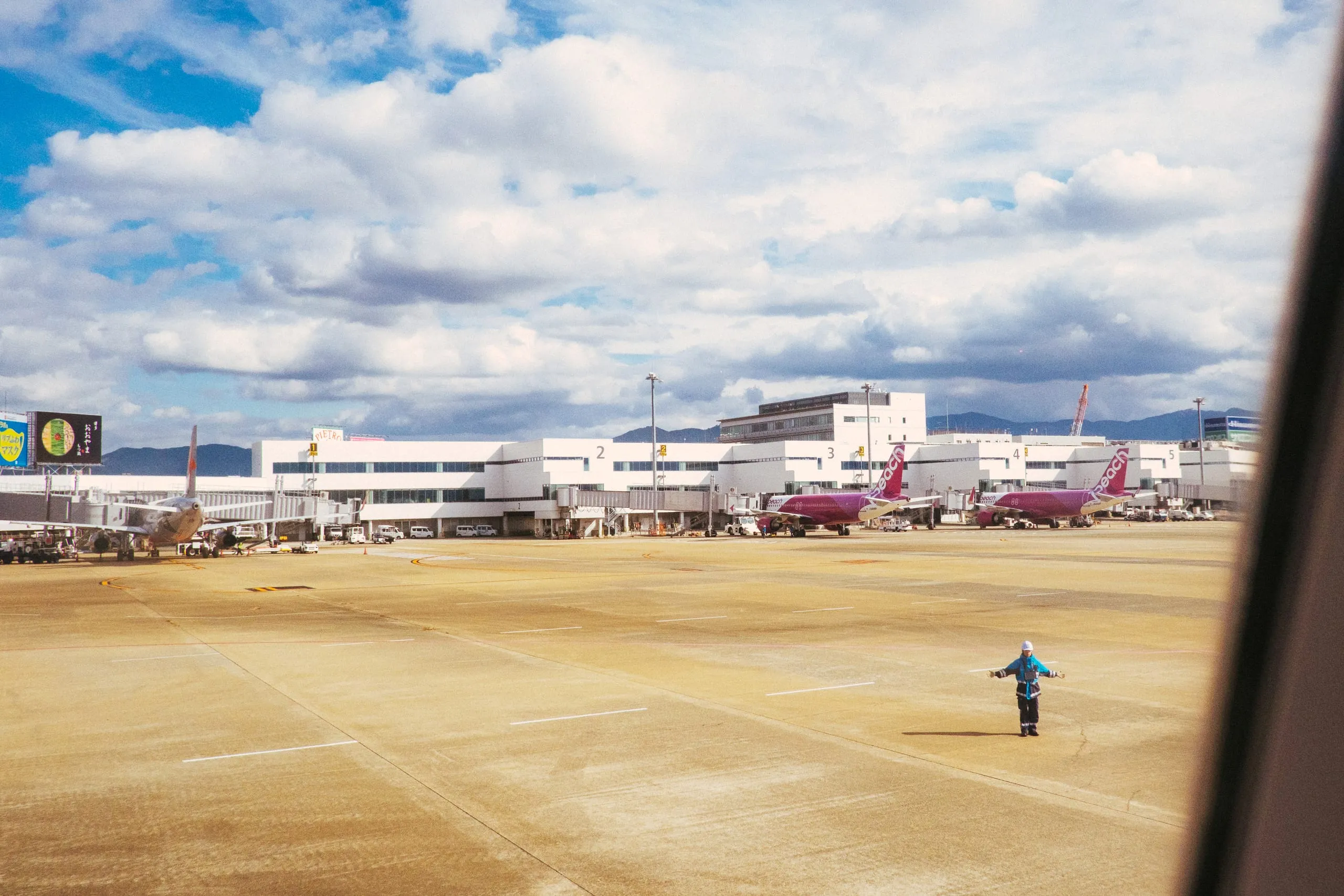A ground crew member signals goodbye on the apron at the airport
