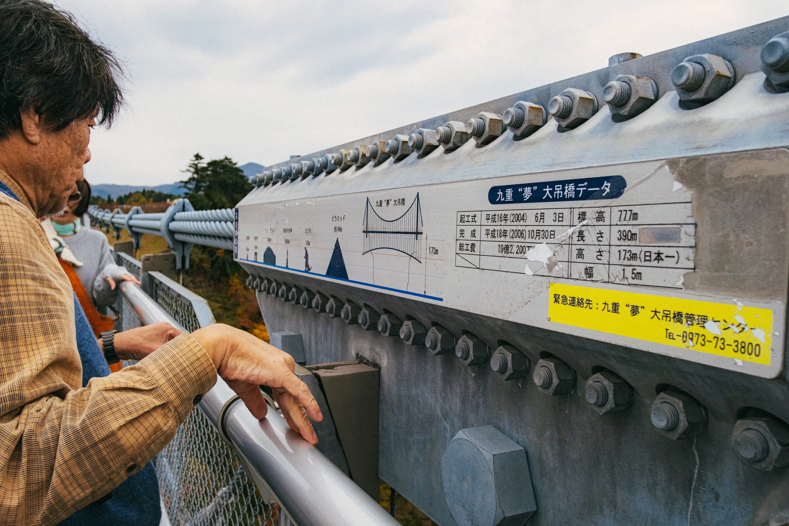 A man looks at the size of Godzilla as recorded on the height-comparison plaque of Kokonoe "Yume" Otsurihashi