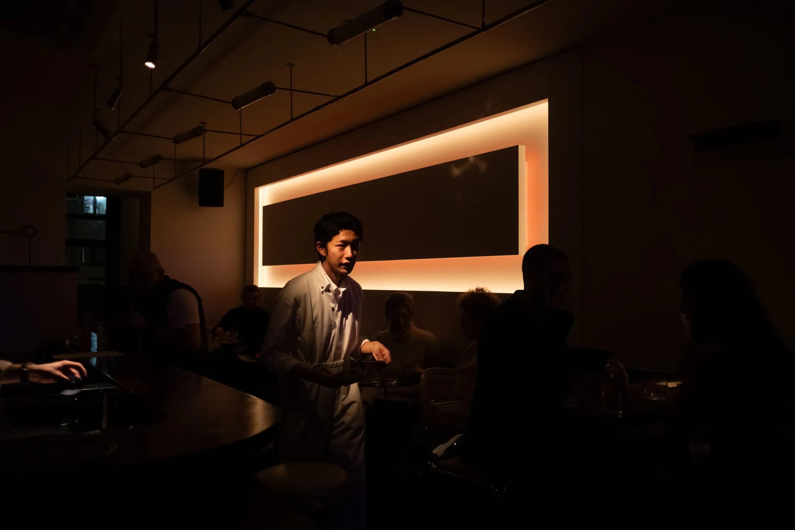 A worker in Bar with Shapes for a Name delivers a drink