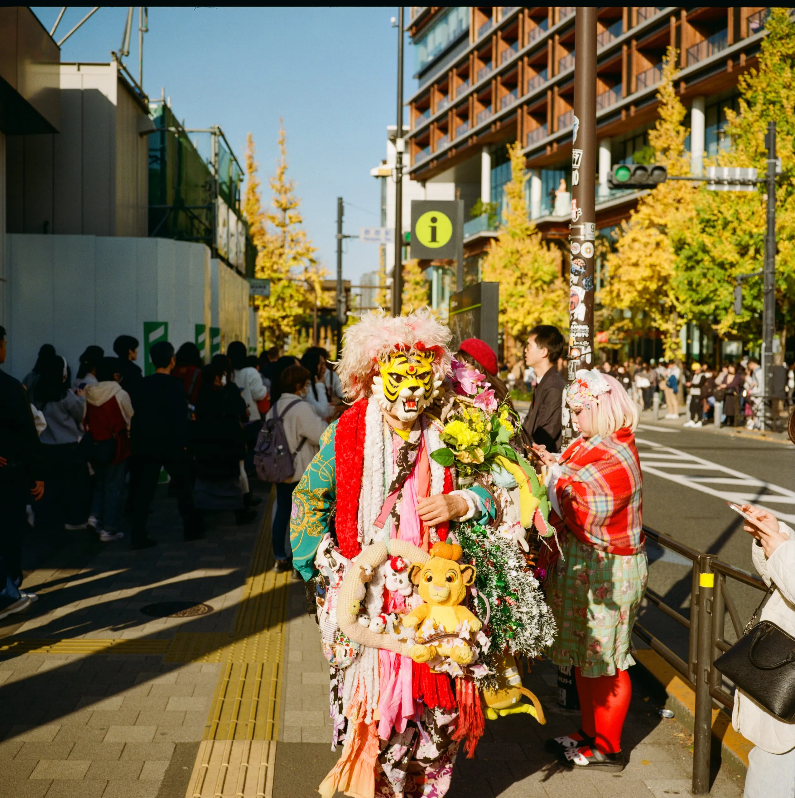 A person in a tiger mask and costume walks past Harajuku station