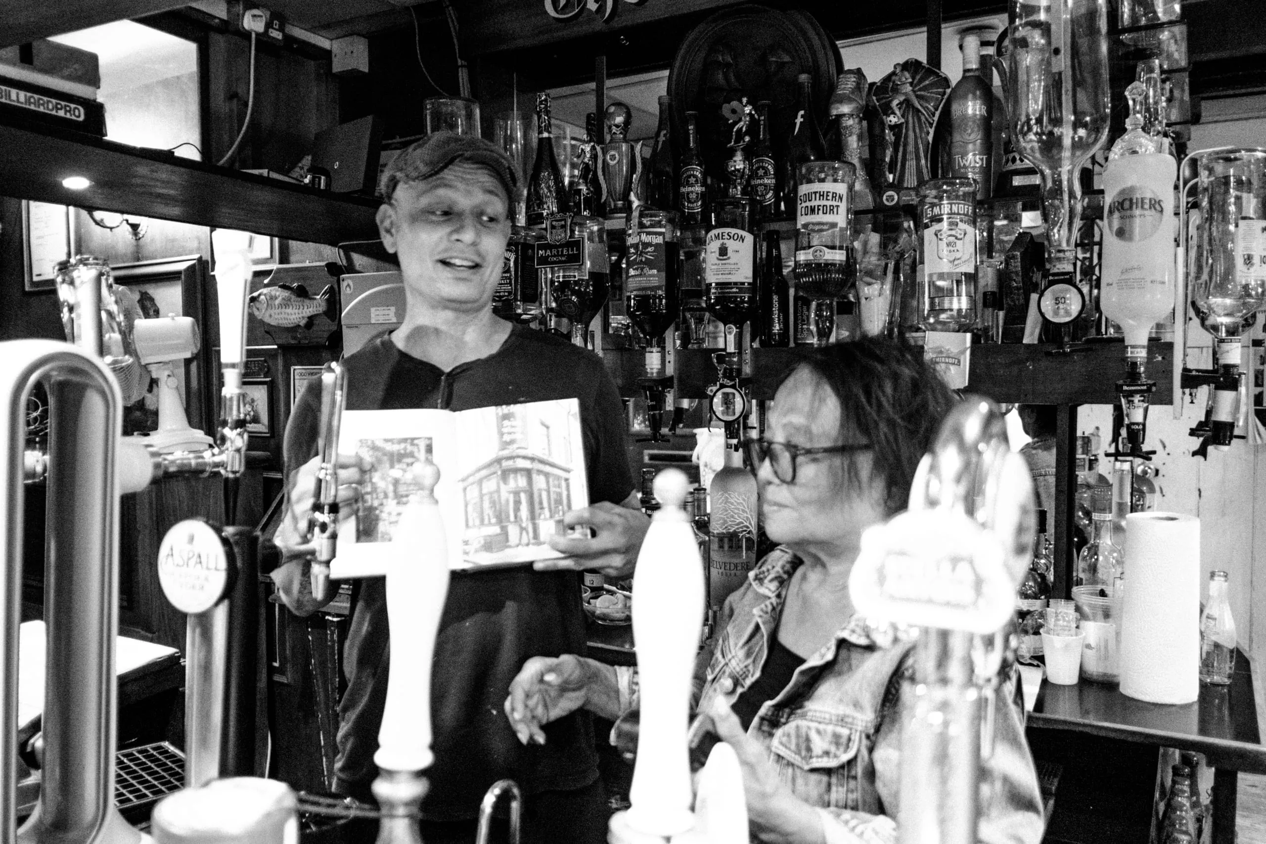 Danny and his mom proudly show the Victory pub's entry on a book of London pubs