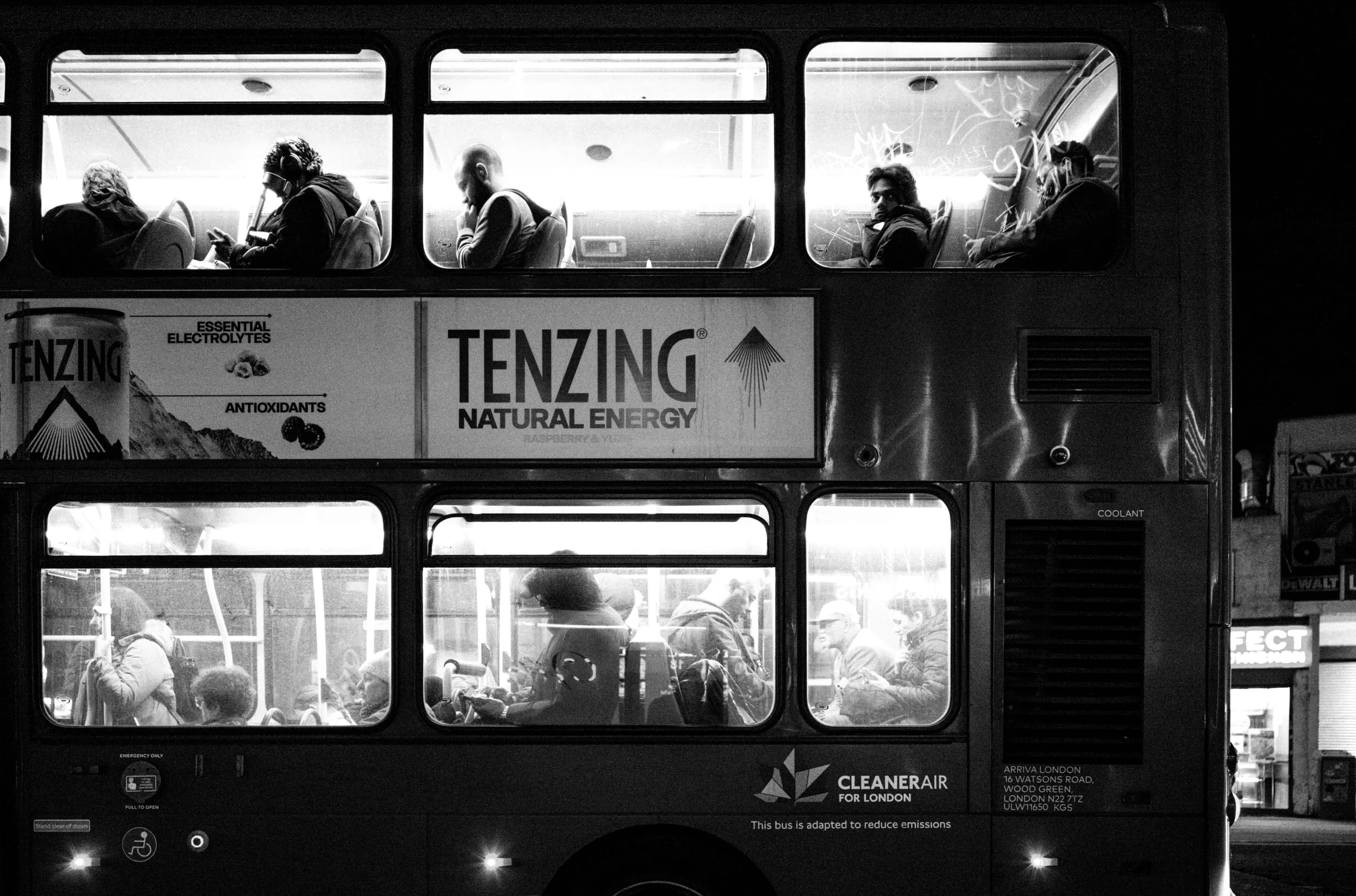A passenger looks out of a sunlit bus window