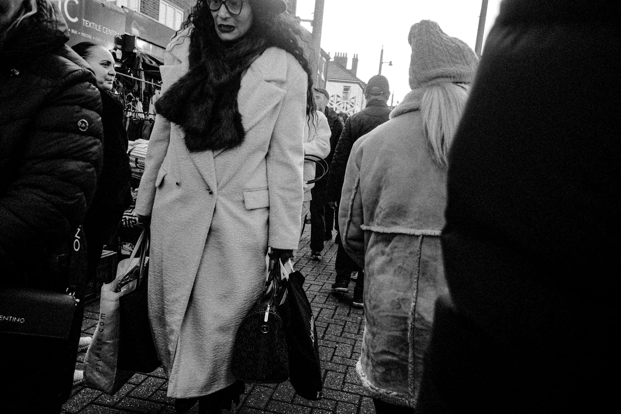 Woman walks through the crowds of Walthamstow Market, Walthamstow