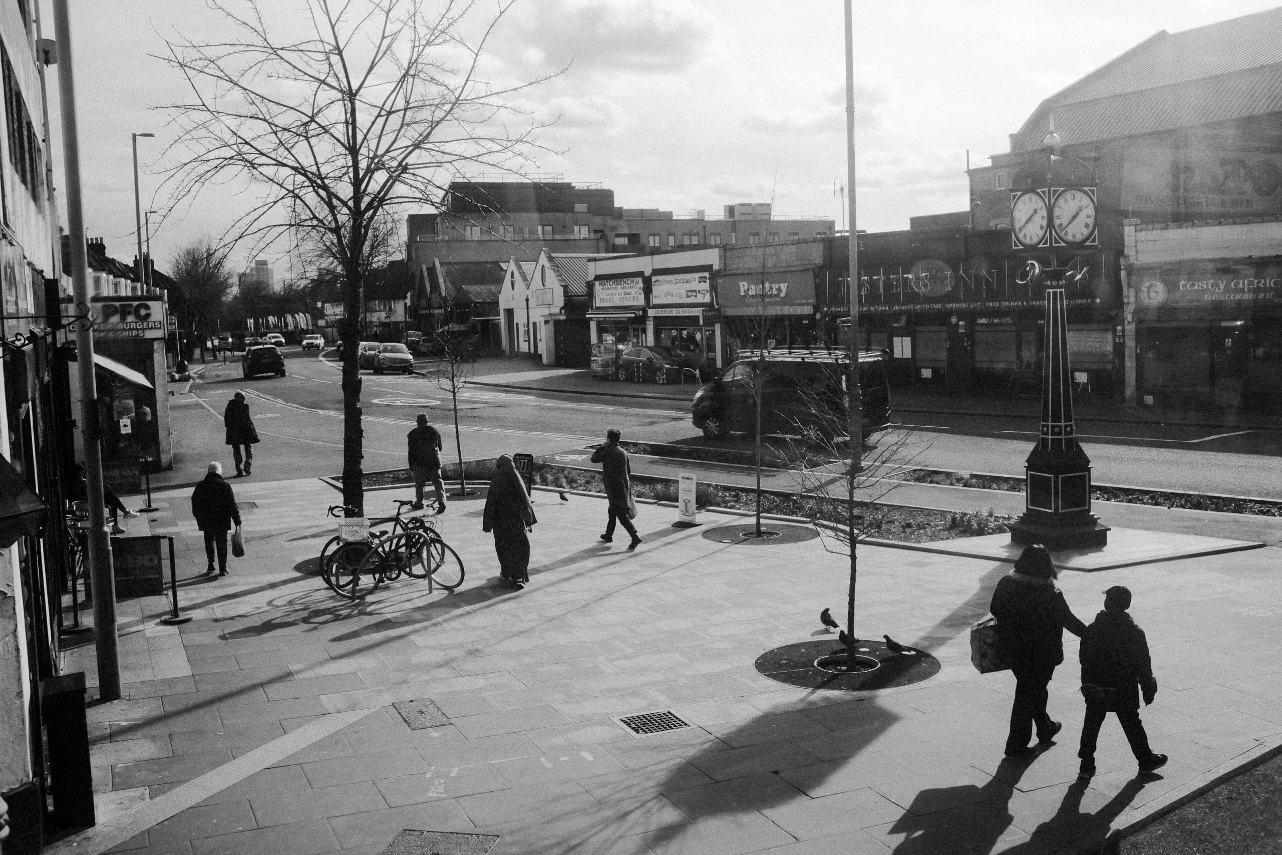 A mother and a son glance upon the newly renovated square, Lea Bridge Road