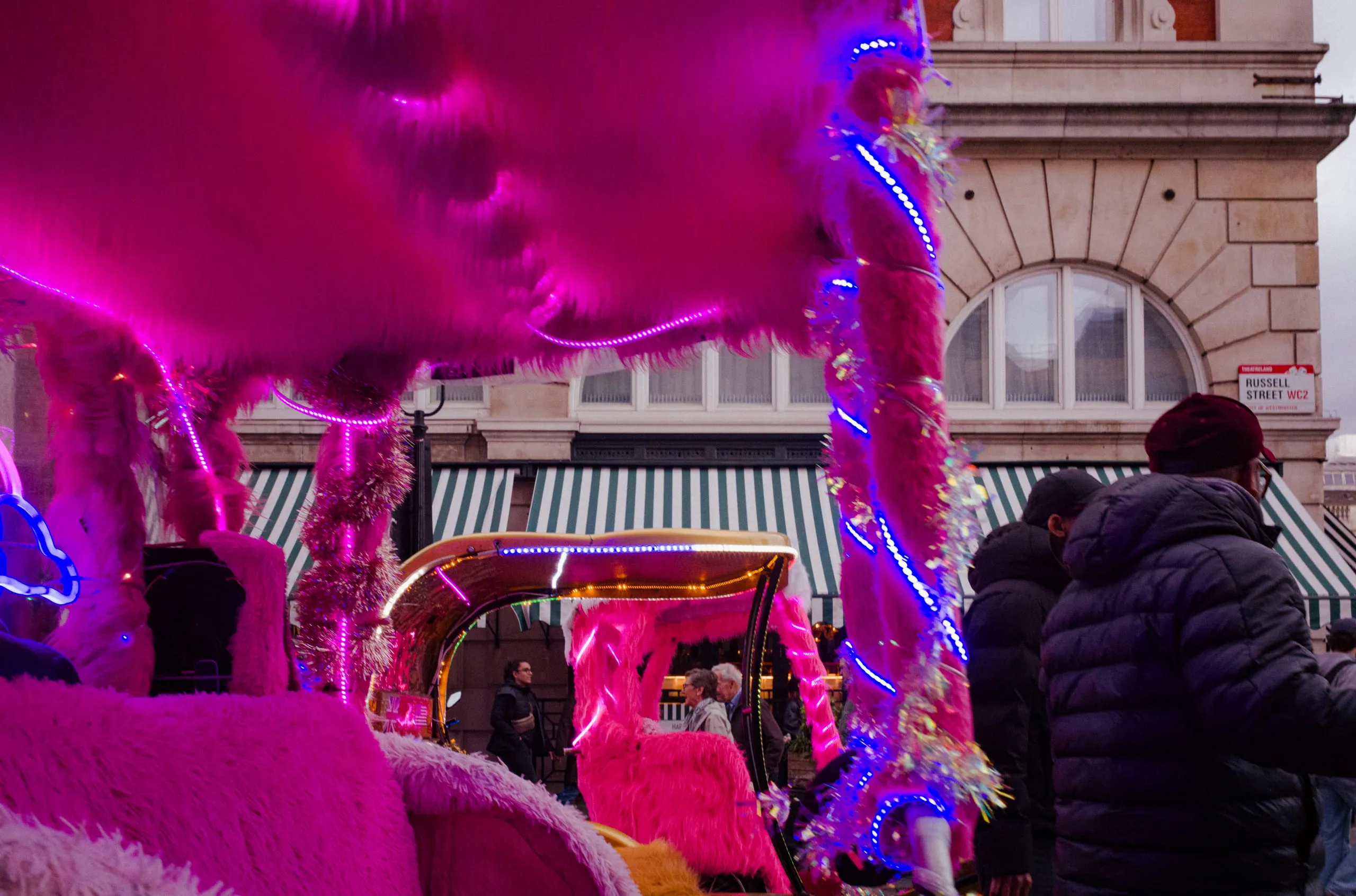 Two pink bike rickshaw drivers wait for their next tourist ride