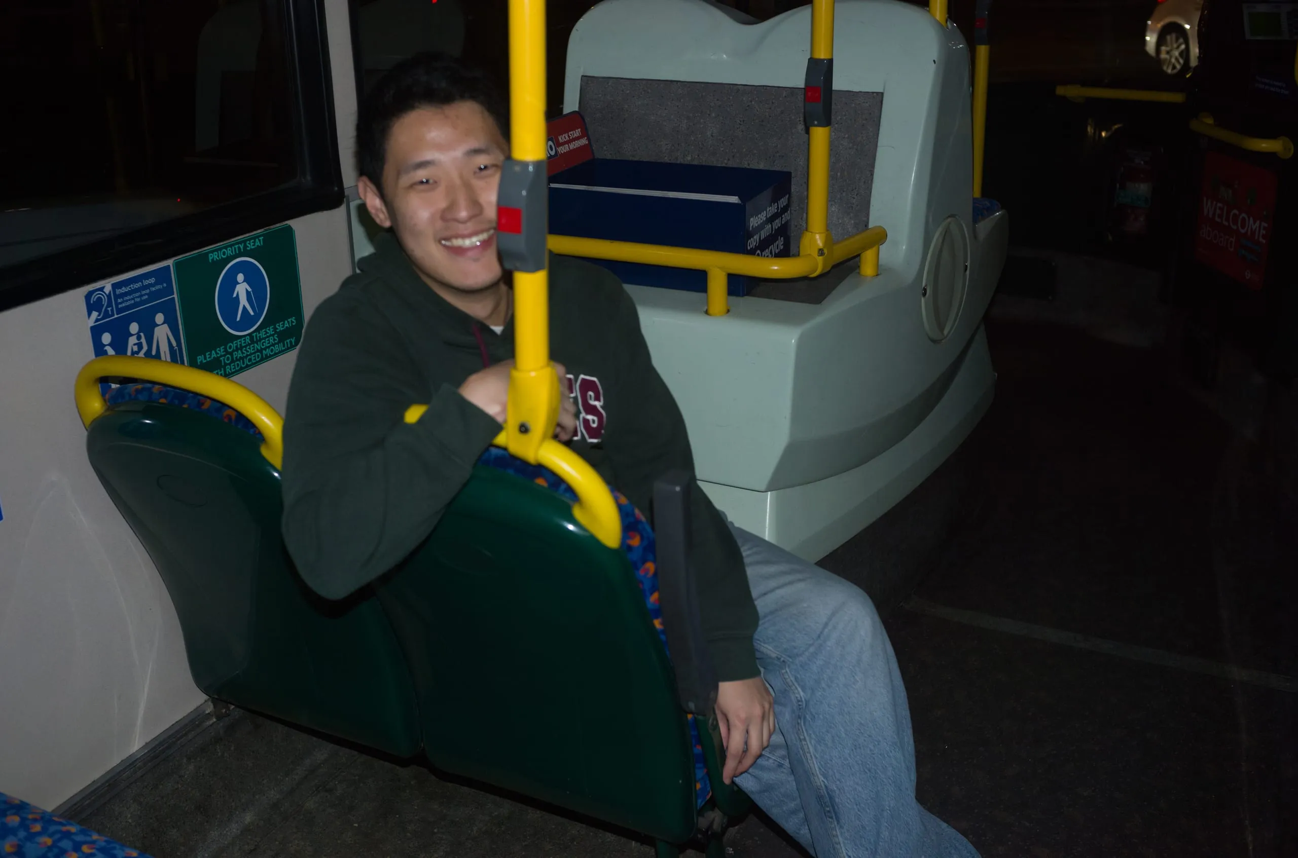 Bo smiles on a near-empty bus at night