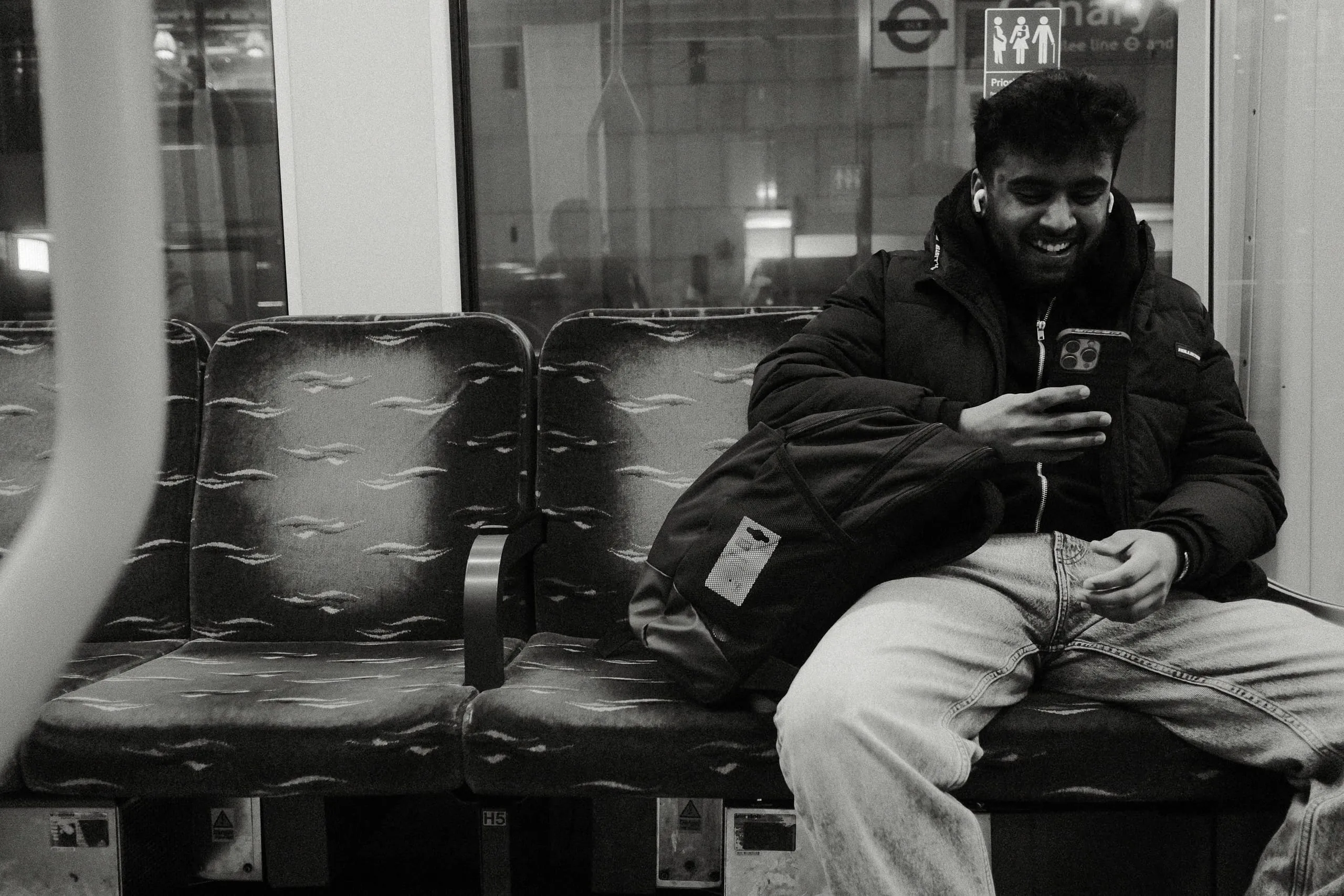 A man enjoys a message from a friend on the DLR, Canary Wharf