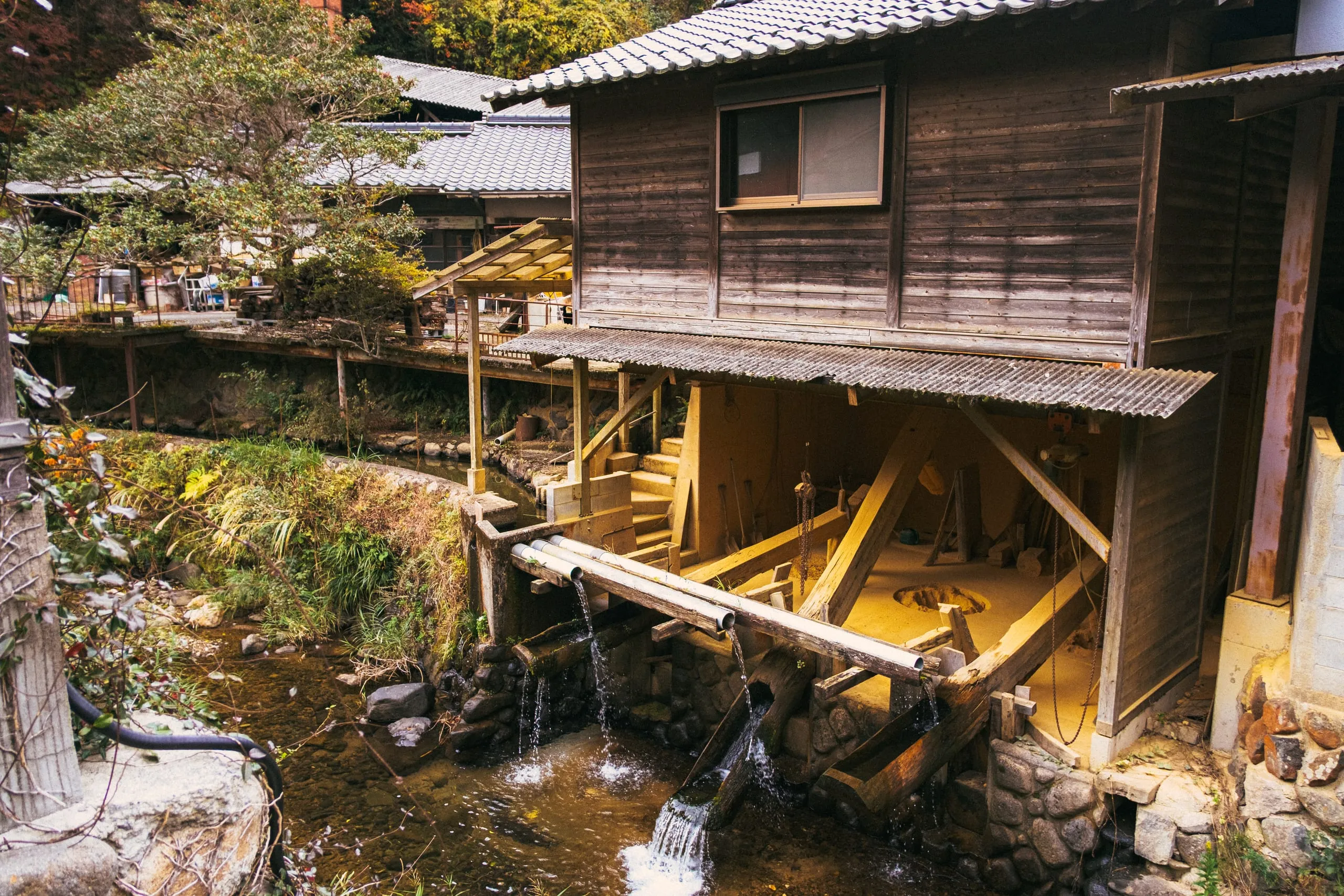 An old wooden waterwheel of a pottery mill beside a stream