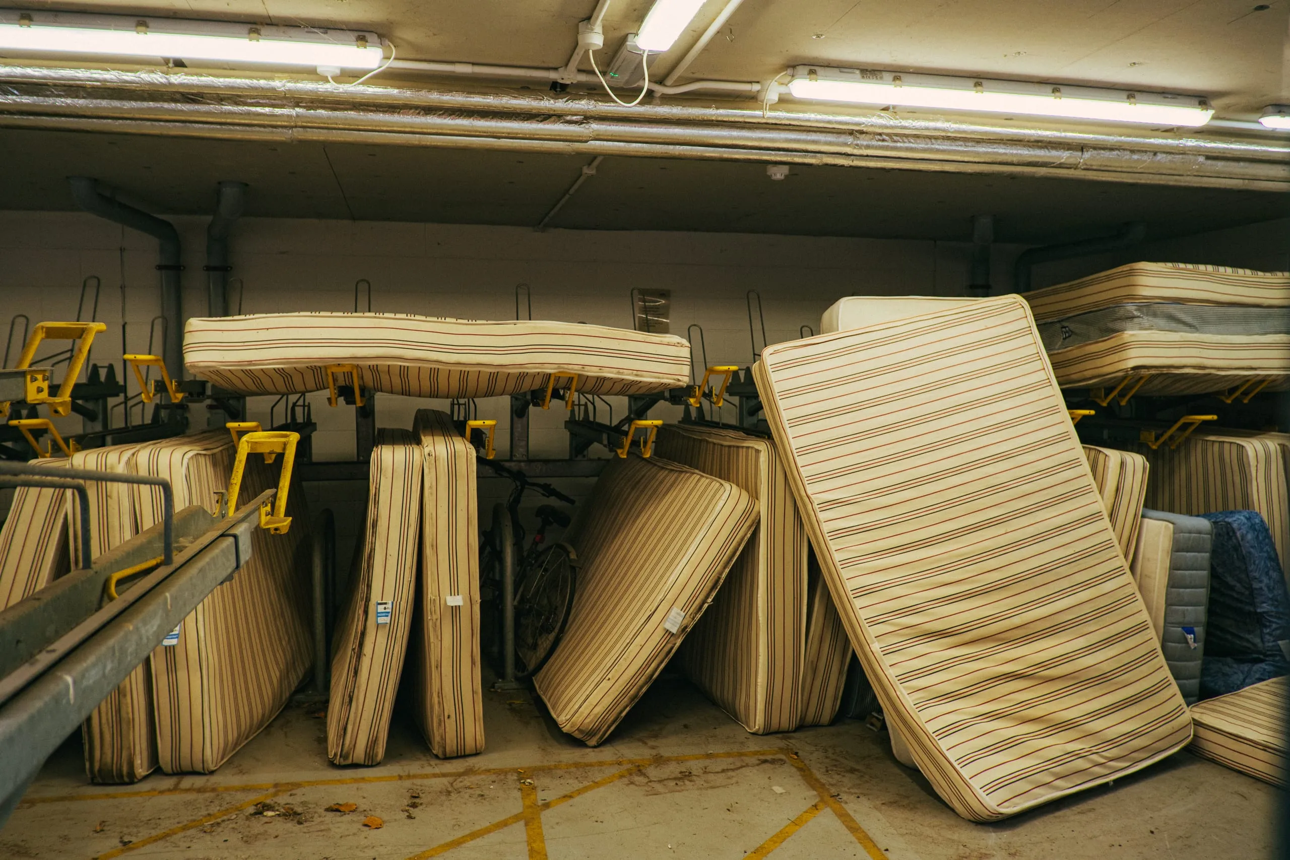 Striped mattresses stored upright in a basement