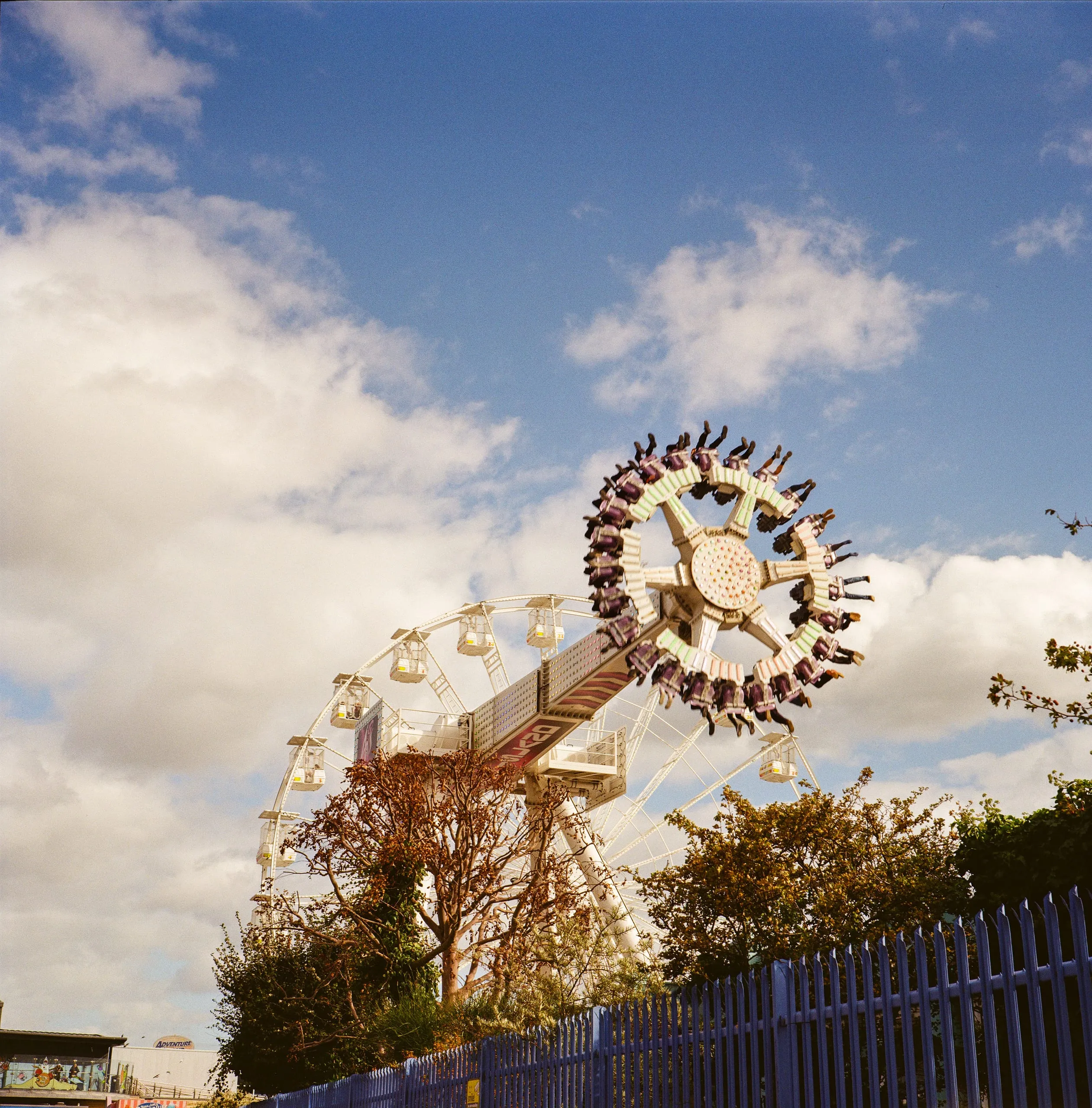 People's legs dangle off a swing ride at Adventure Island