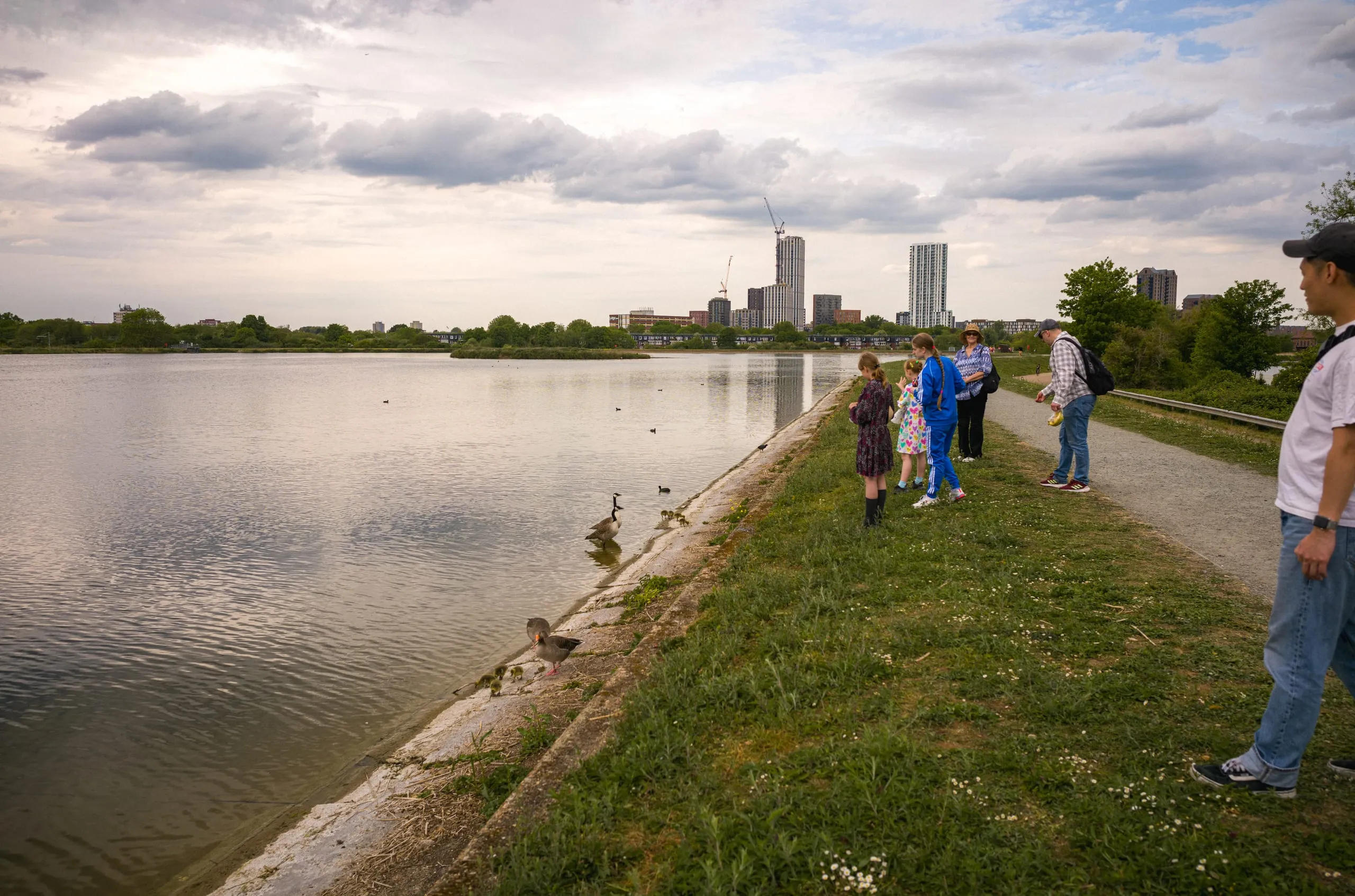 A family feeds ducks on Walthamstow Wetlands water reservoir