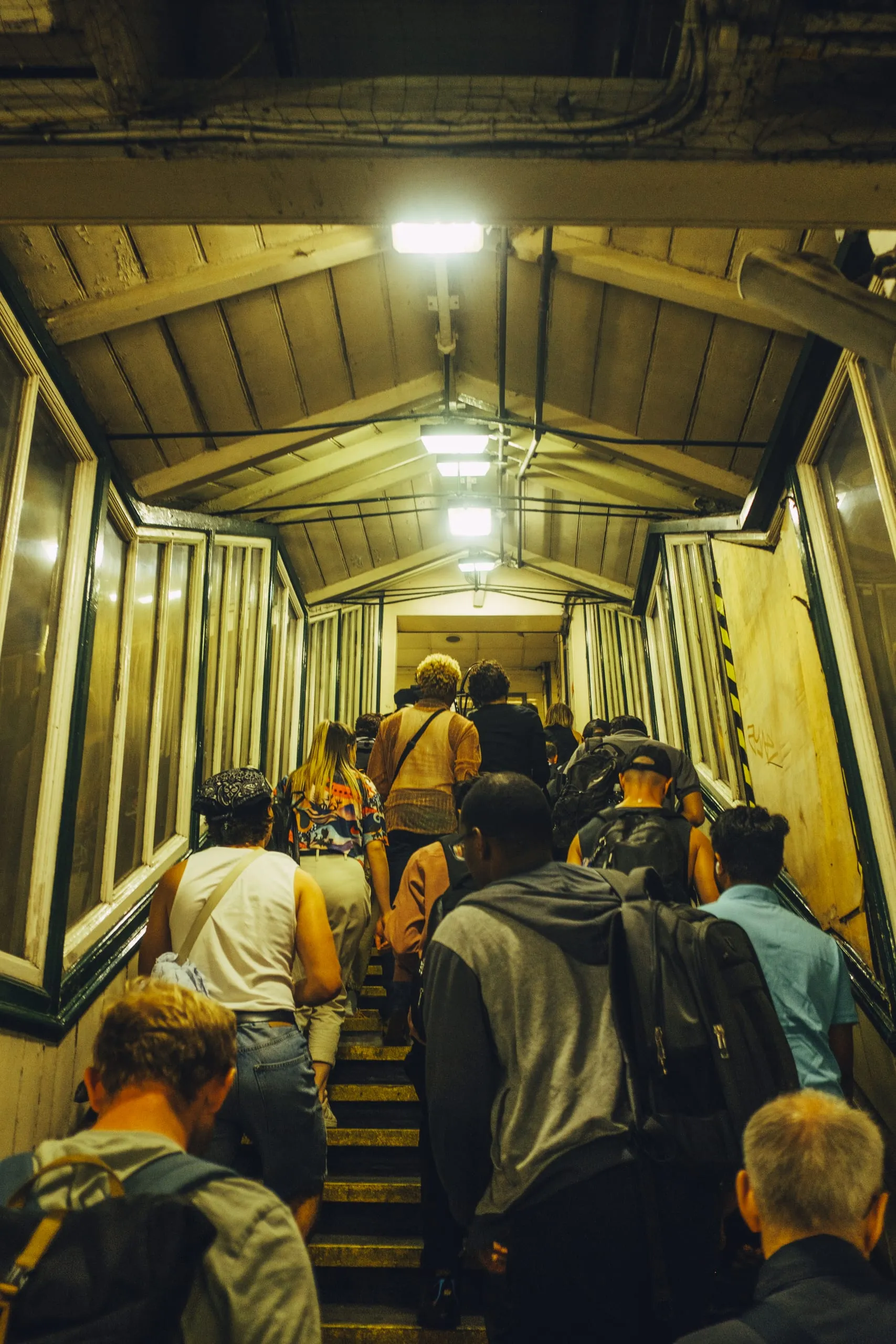 Passengers climb a covered staircase out of Leyton underground station