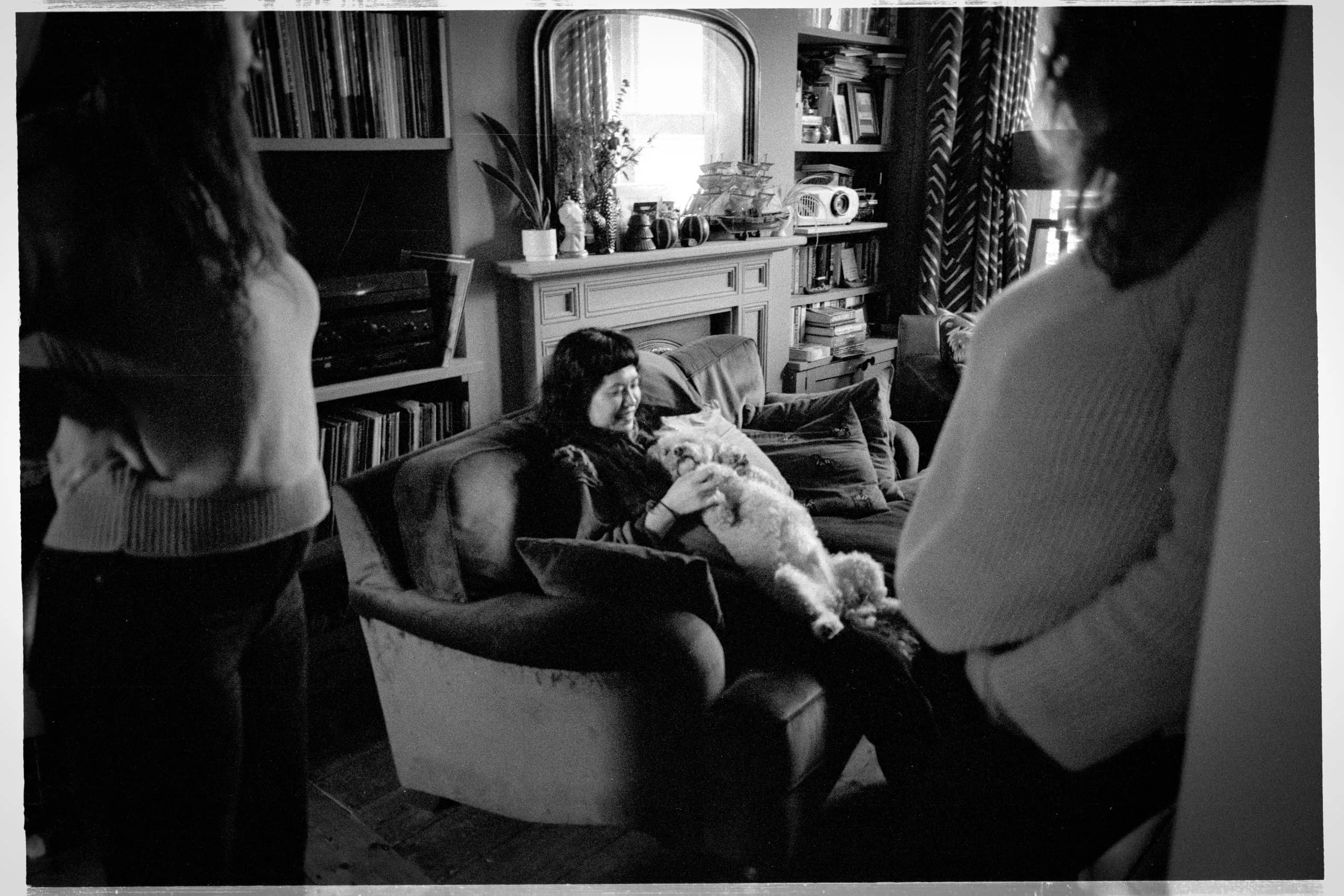 Sei sits with Bowie in a Victor's living room as others look on by