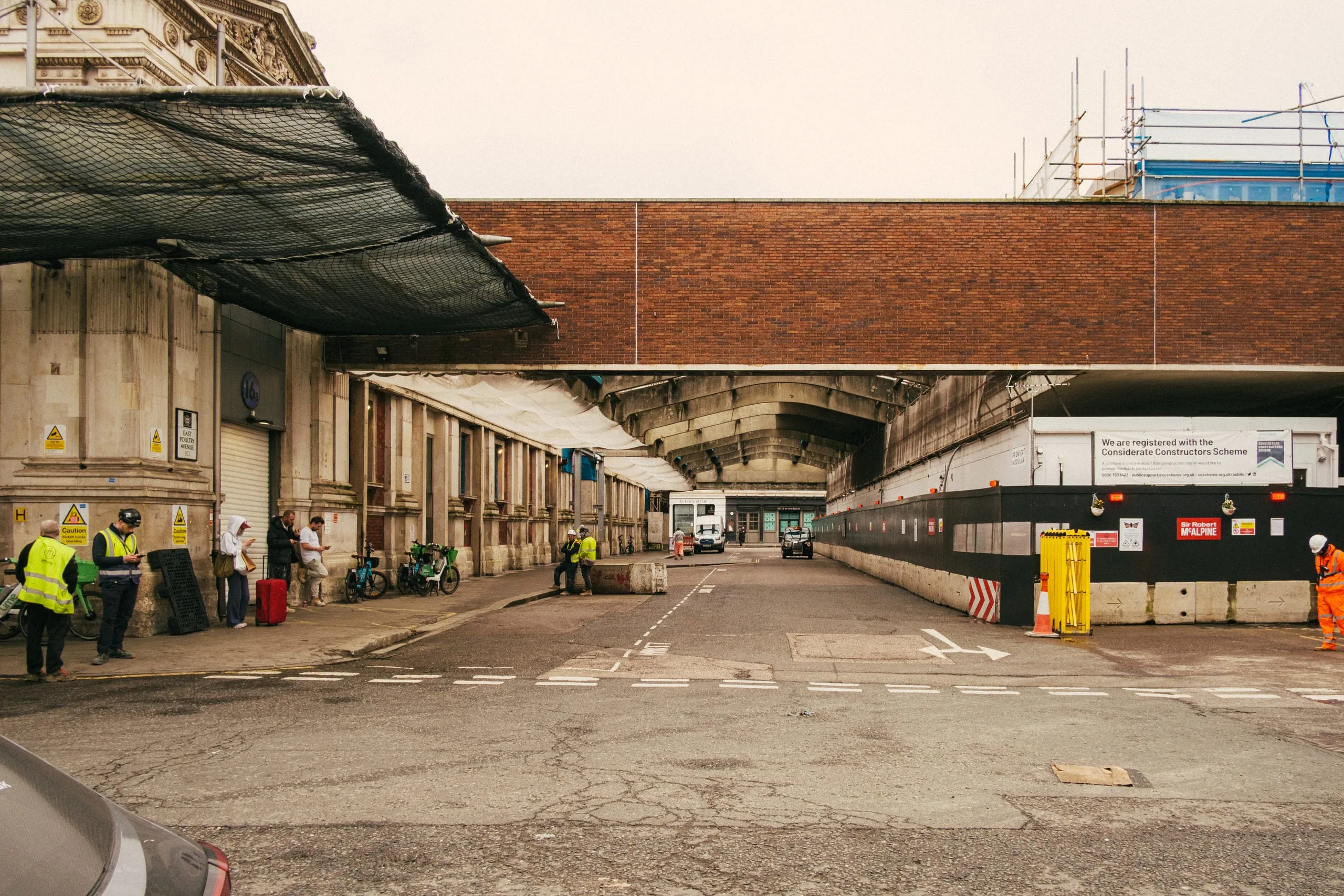 Smithfield Market Workers in hi-vis stand on their phones whilst on a break