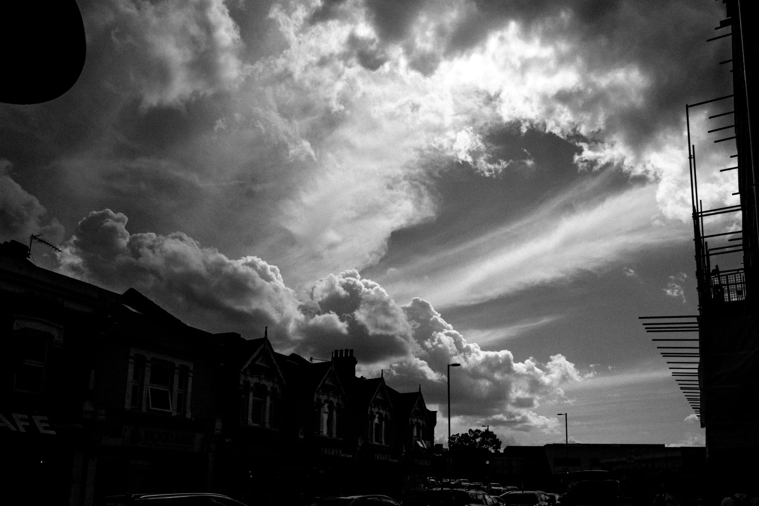 Clouds break over a terrace of rooftops and shopfronts, Blackhorse Road