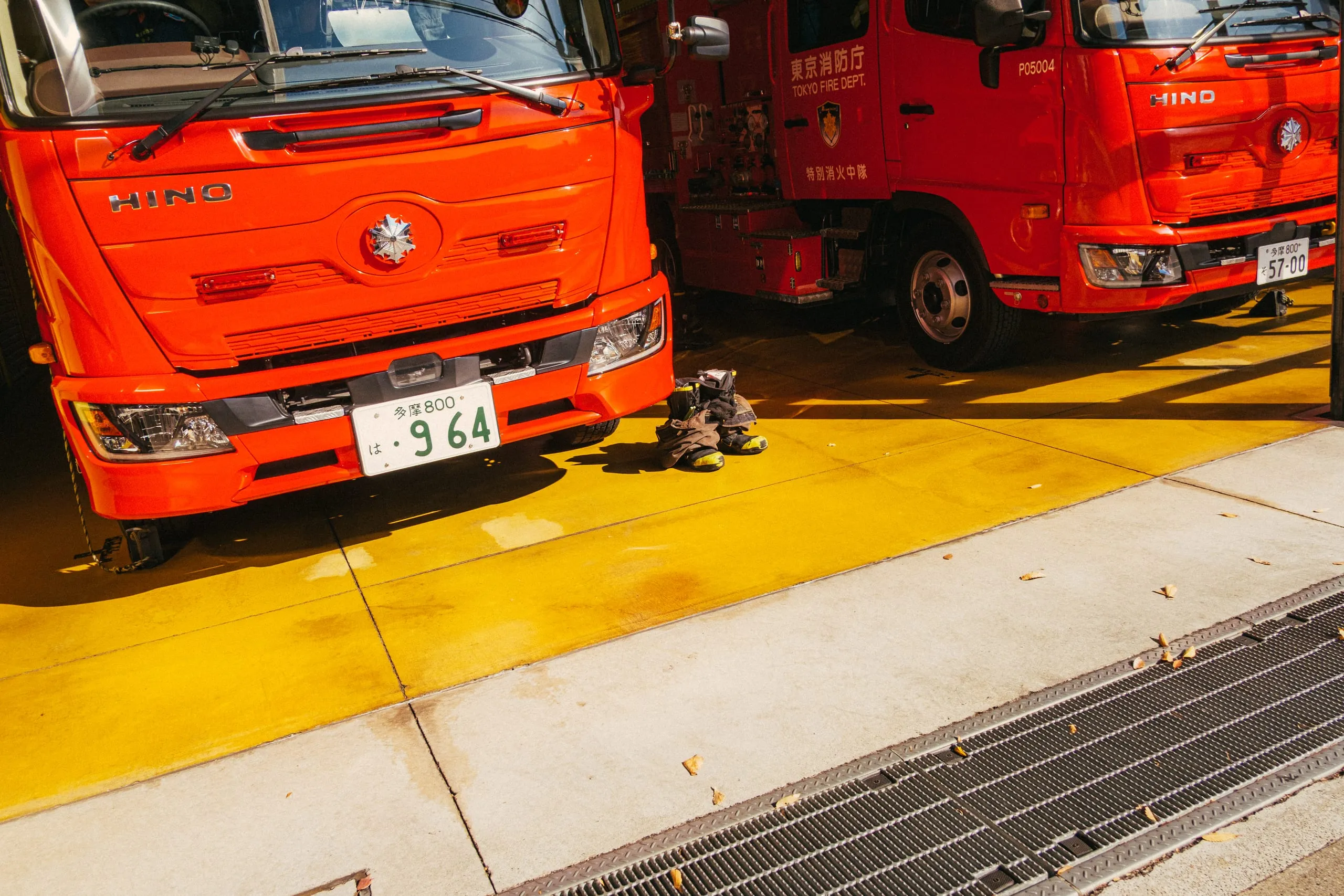 Firefighting gear laid out beside red fire engines