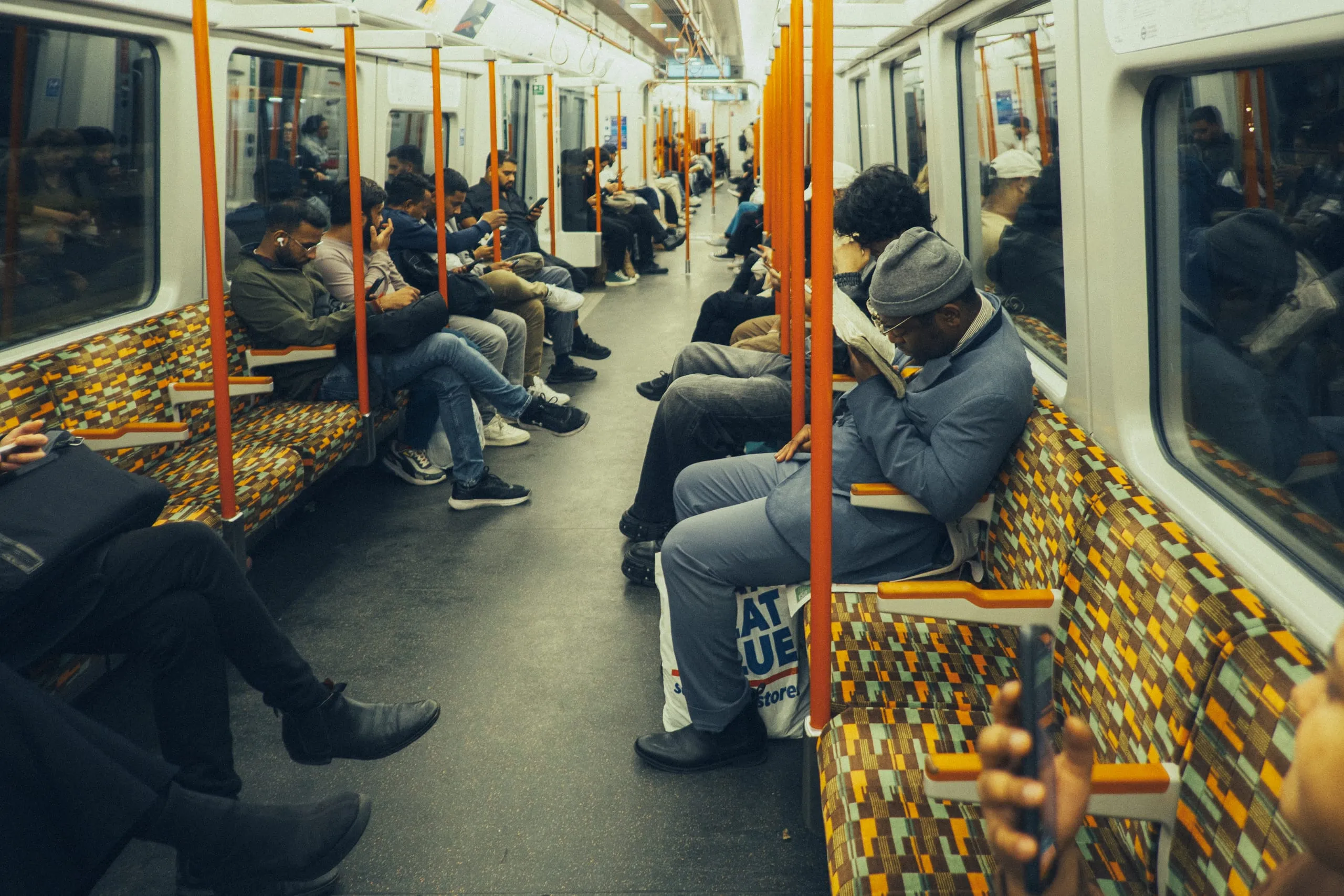 Passengers sit reading and on their phones on an Overground train