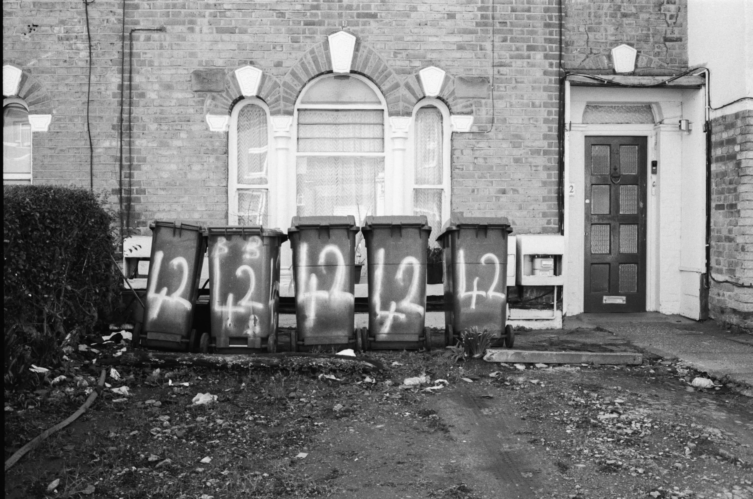 A row of spray-painted wheelie bins, Leyton
