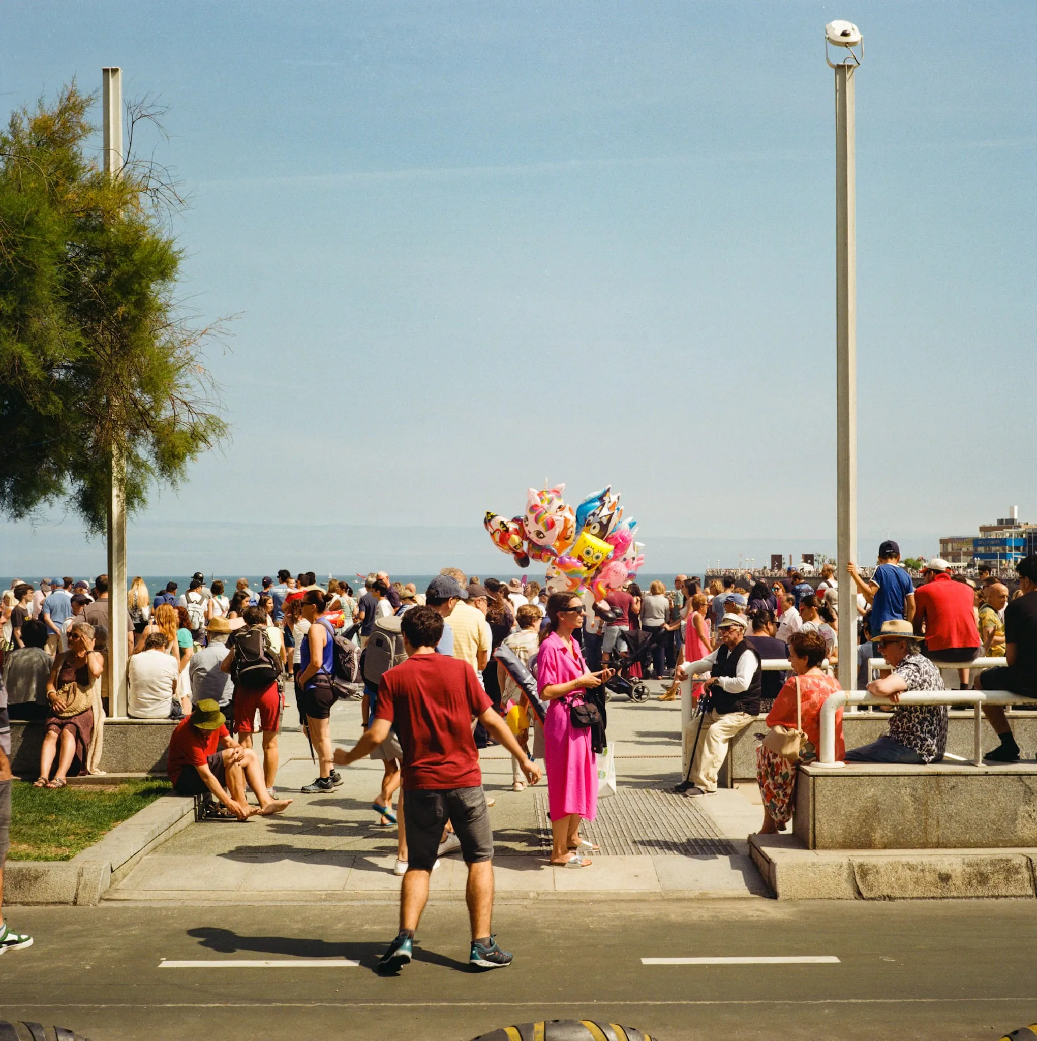 A child crosses the road onto a crowd of people waiting for an airshow
