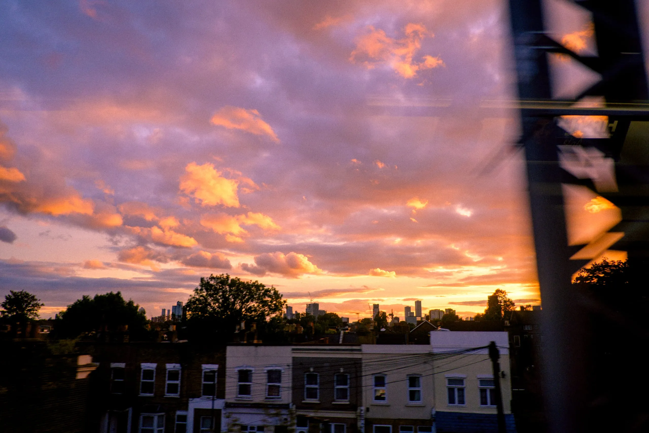 Sunset clouds over terraced houses, seen from a train