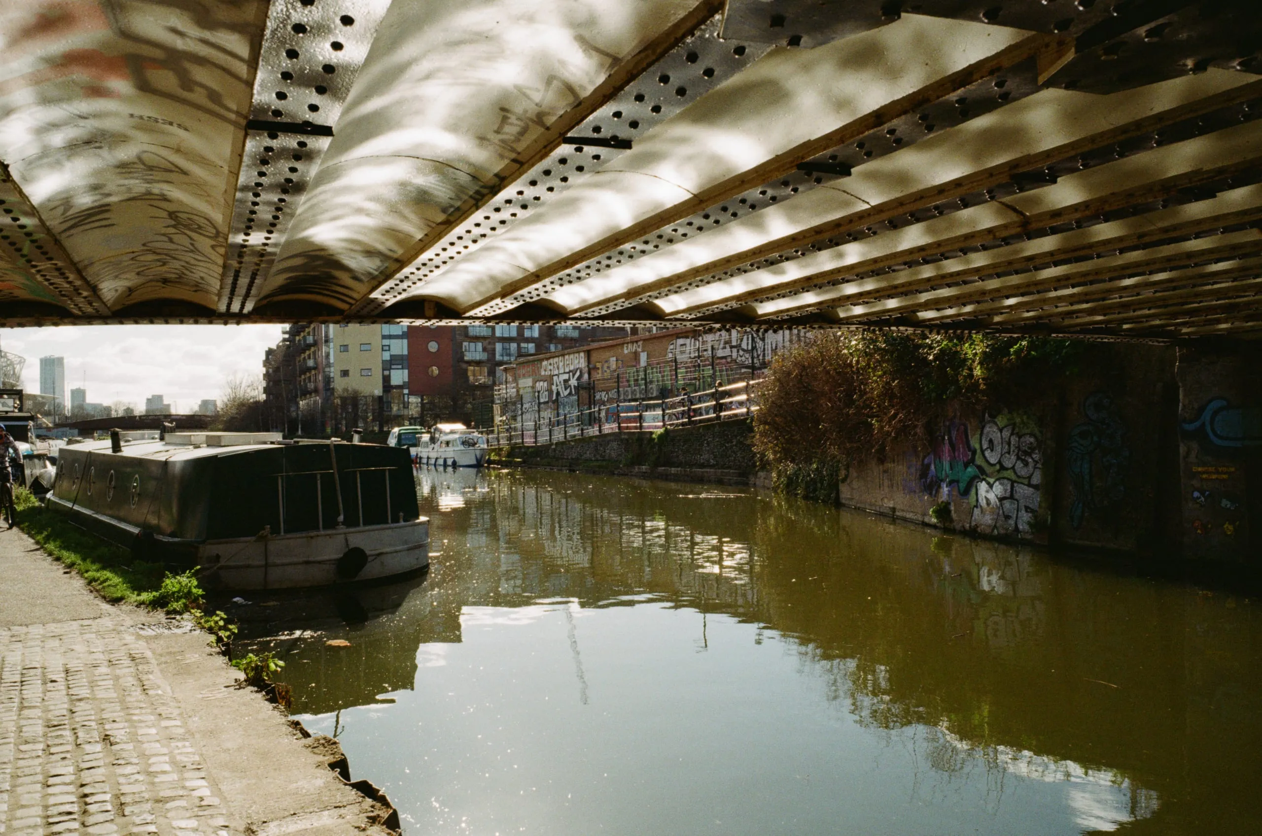 Canal water reflects on the underside ceiling of a tunnel