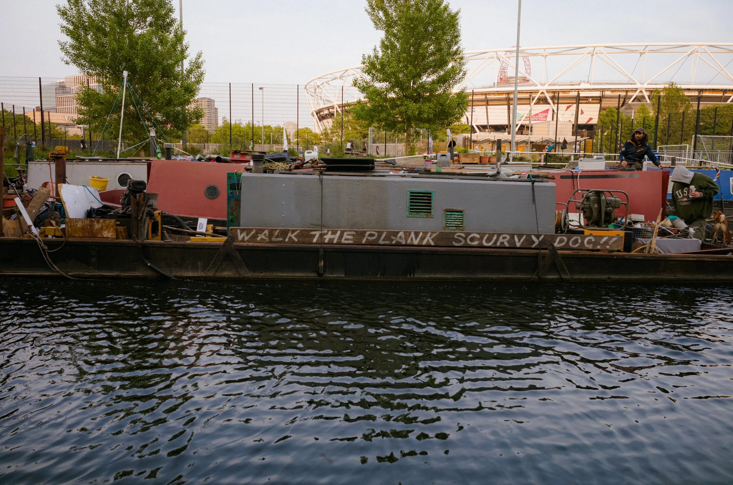 Men drive a boat named "Walk the plank scurvy dog!!" up the Lee Navigation Canal