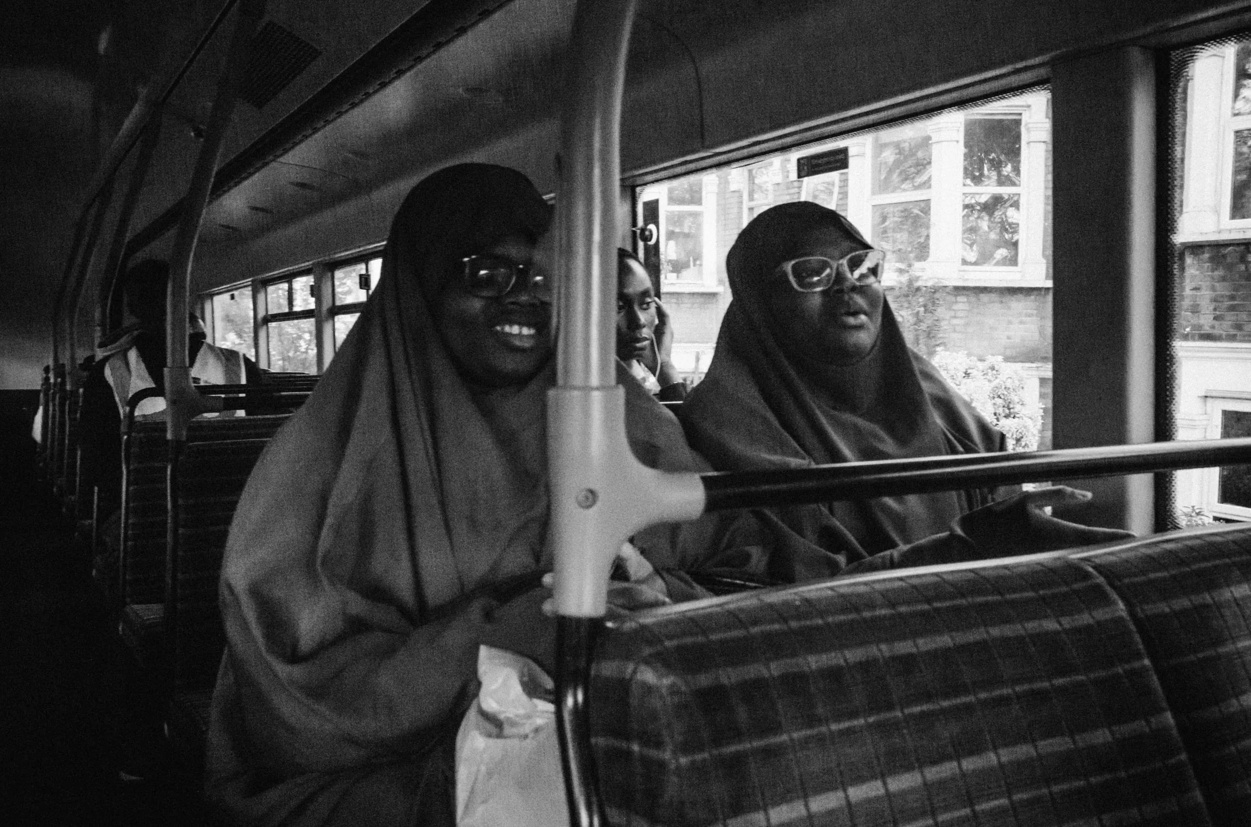 Two women sit together on a bus