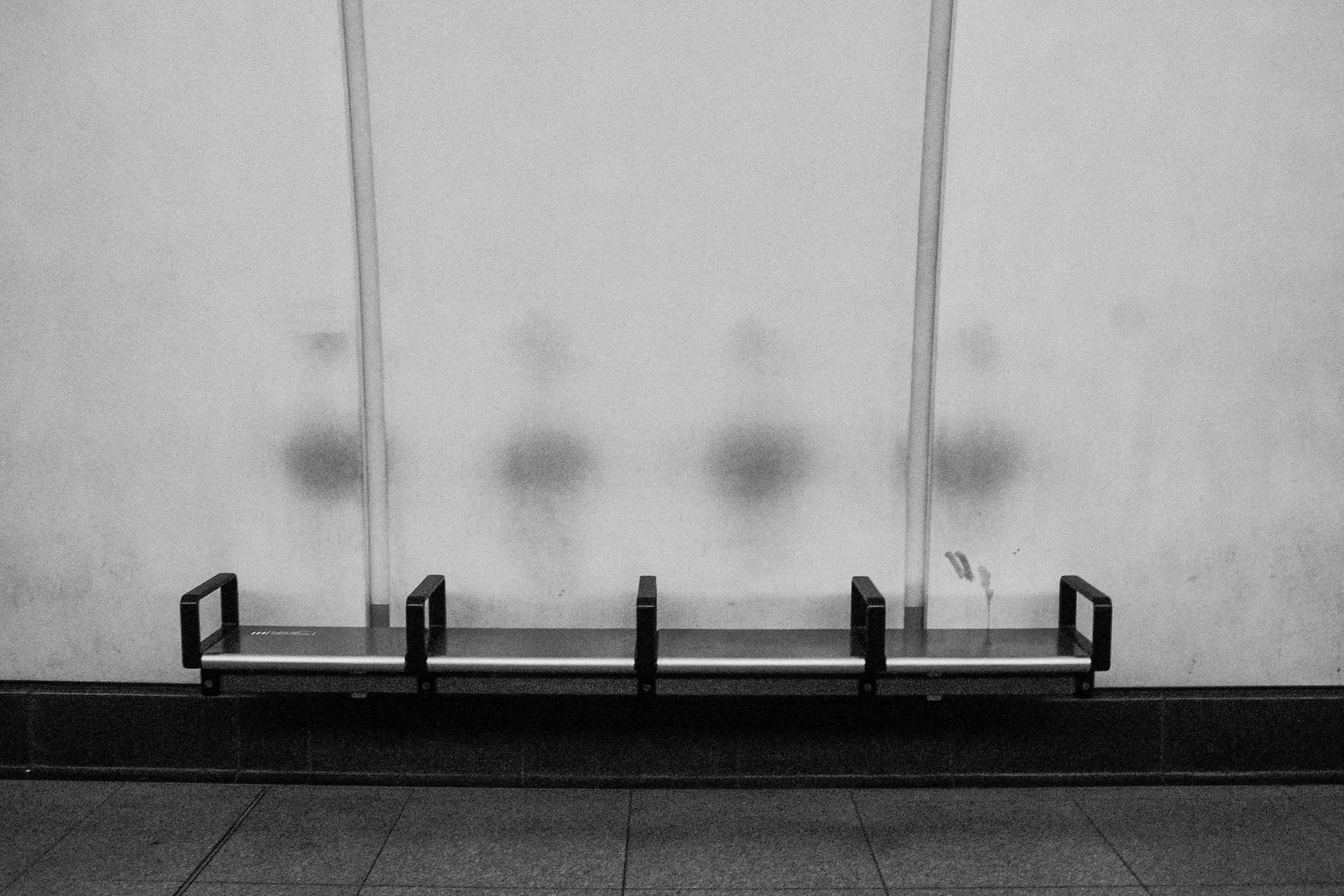 Sweat marks on white concrete left behind by passangers waiting for the Elisabeth Line, Tottenham Court Road